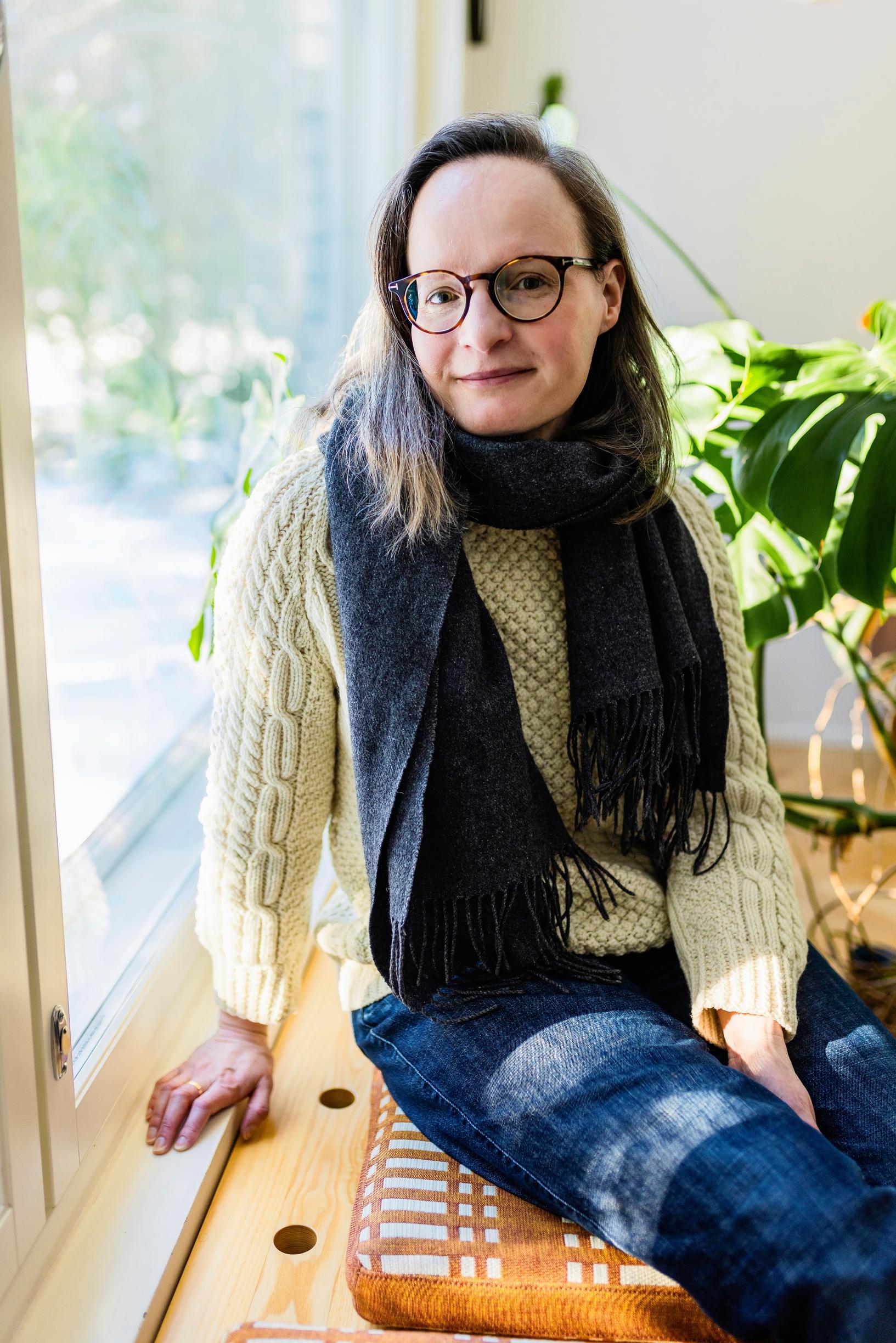 Minttu istuu ikkunalaudalla auringonpaisteessa.