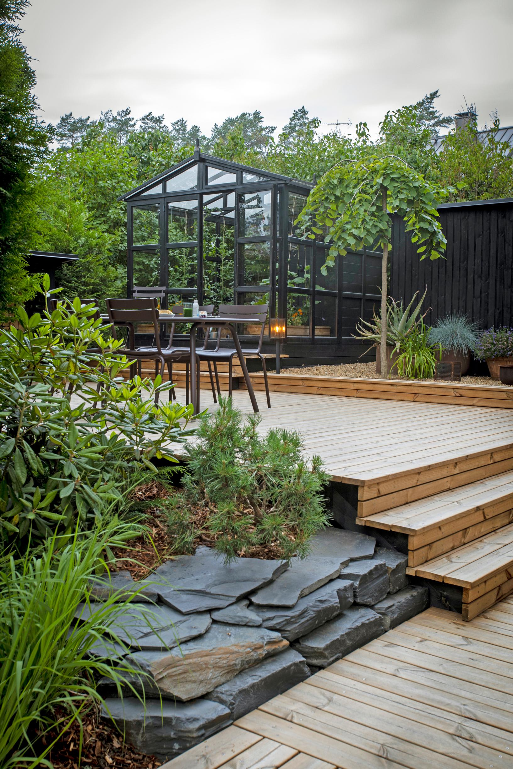 Liuskekivillä reunustettu istutusalue terassin reunalla