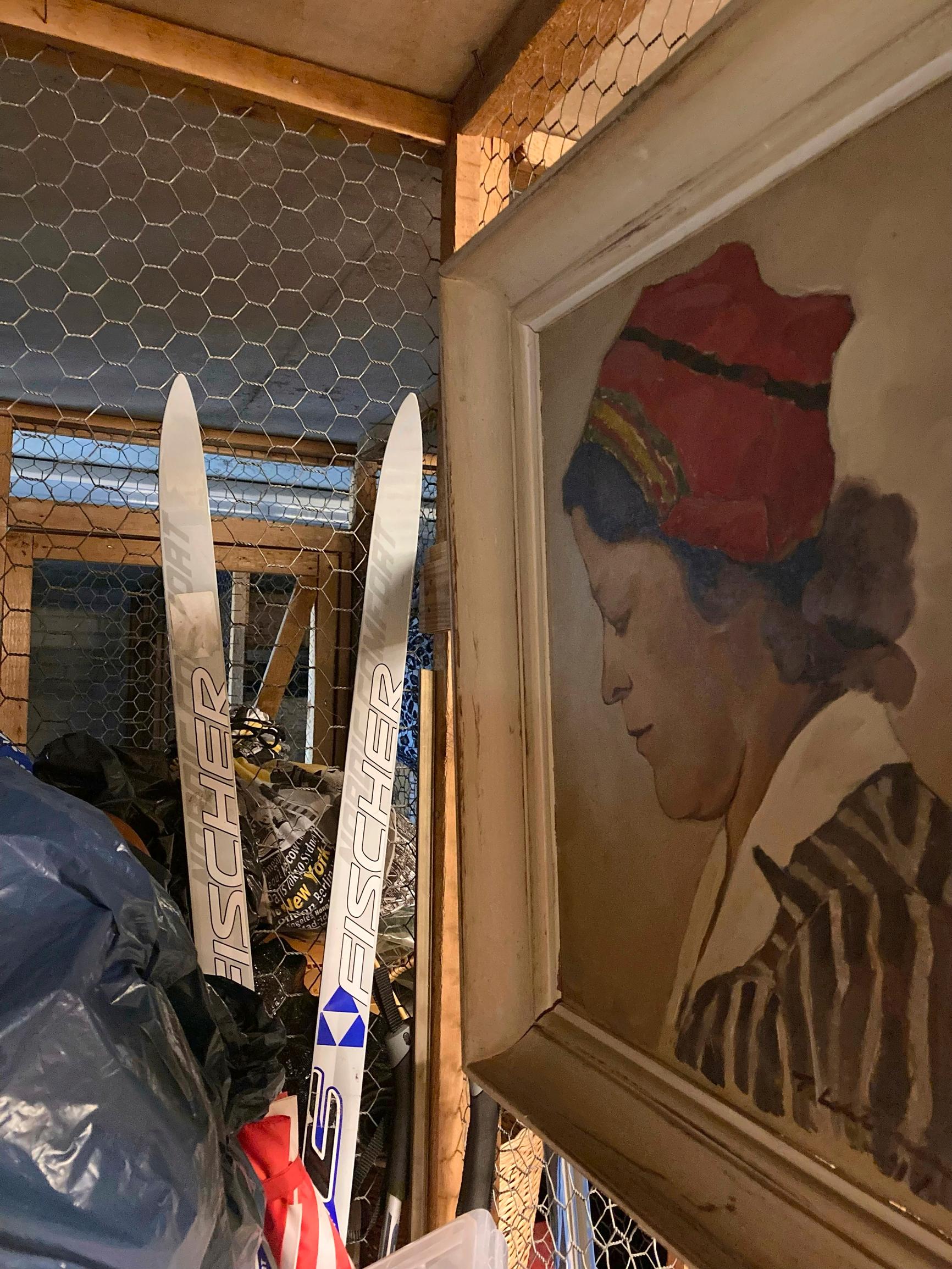 häkkivarasto, jossa näkyvillä sukset, taulu sekä säilytyspussi