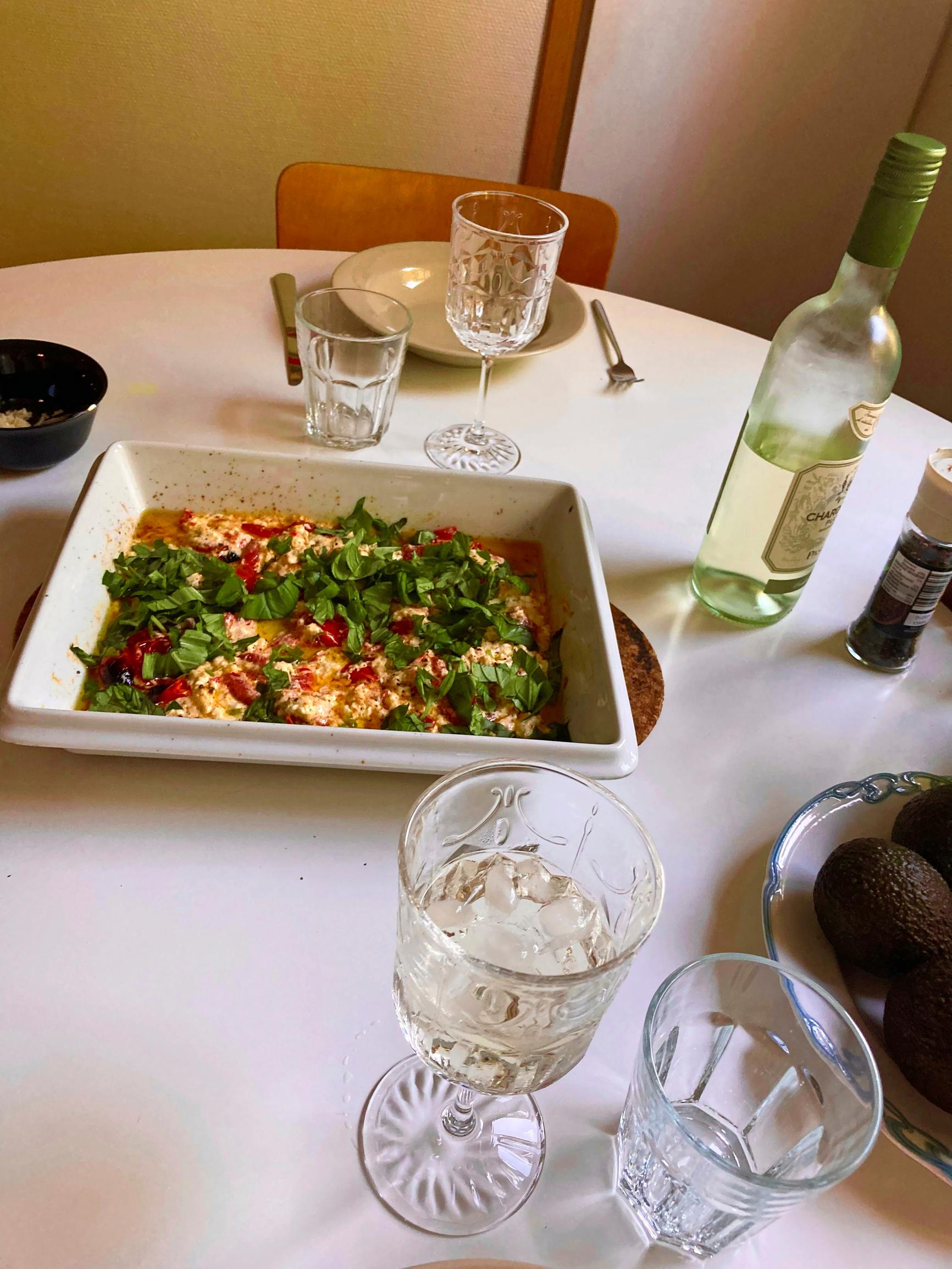 katettu pöytä, jossa tarjolla uunifetapastaa ja viiniä