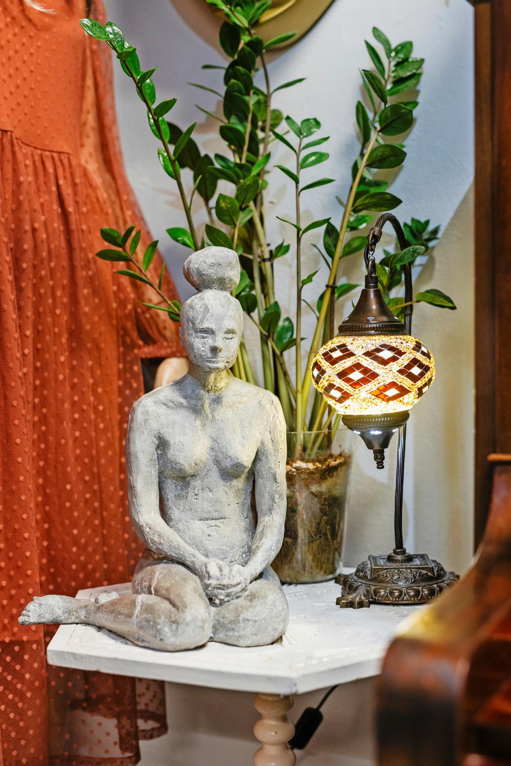 pöydällä on naista esittävä veistos