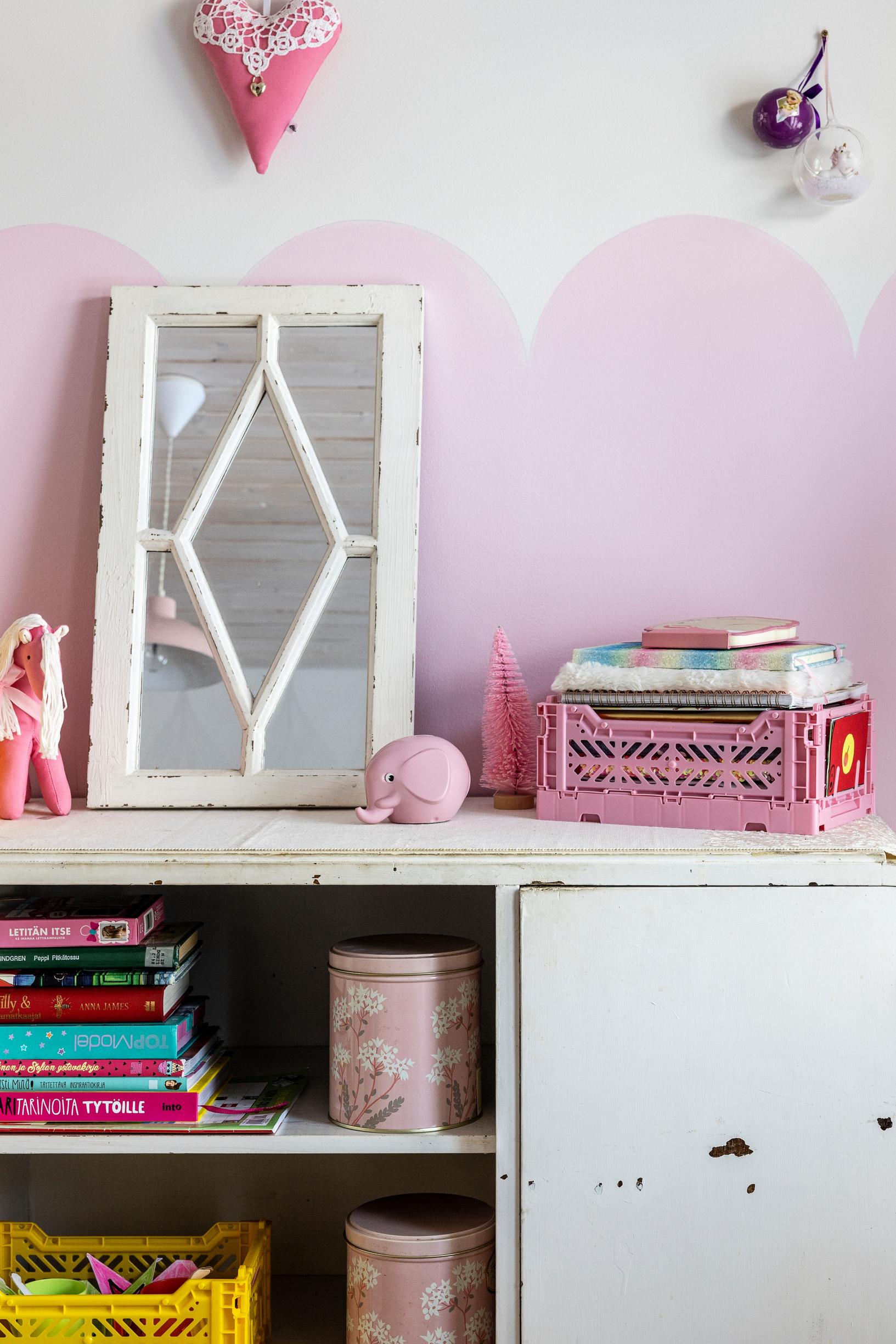 Lastenhuoneen vaaleanpunaiseksi maalattu seinä piparkakkureunalla.