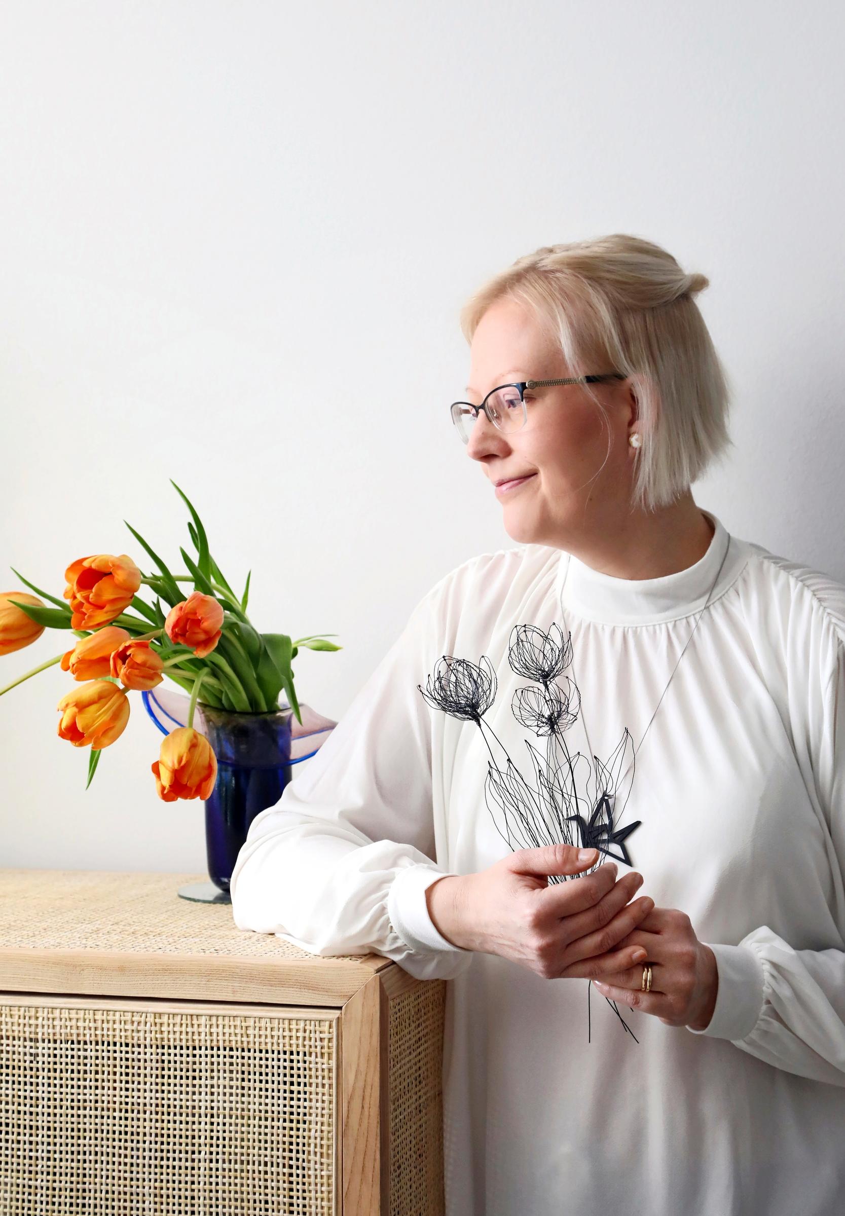Pia kädessään rautalangasta tehtyjä tulppaaneja.