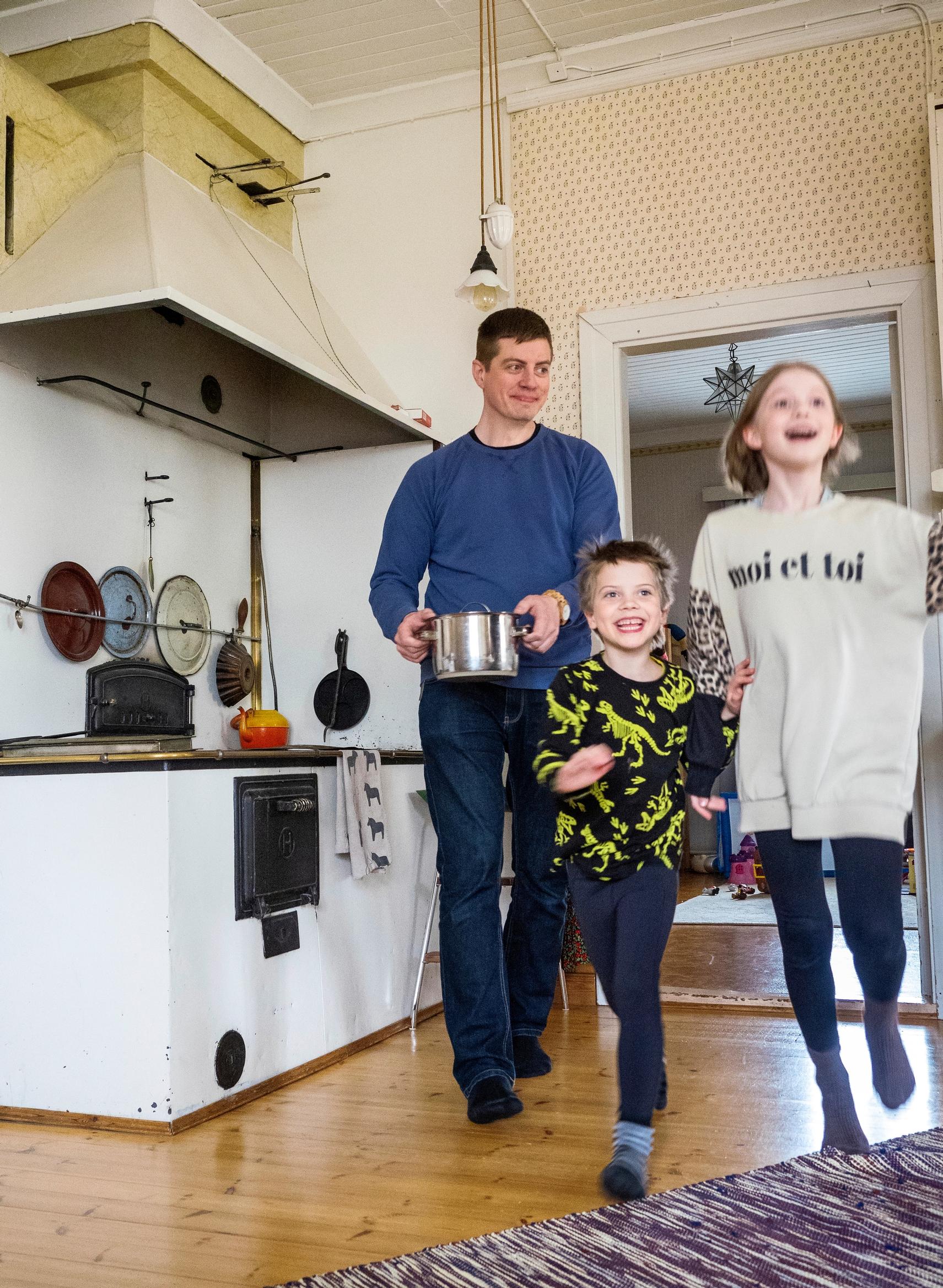 mies kantaa kattilaa, lapset hyppelevät edessä