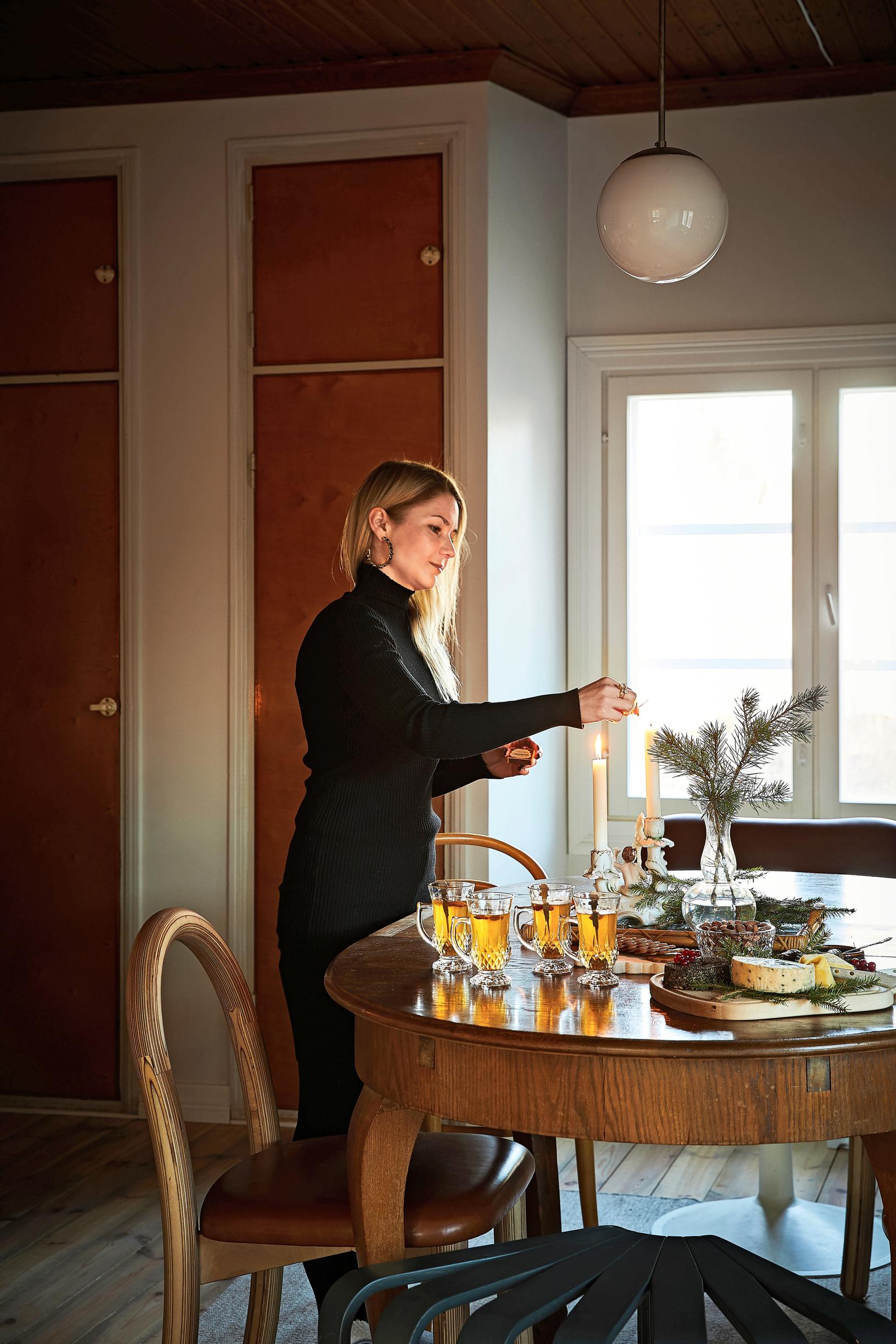Anna Helminen sytyttää kynttilän
