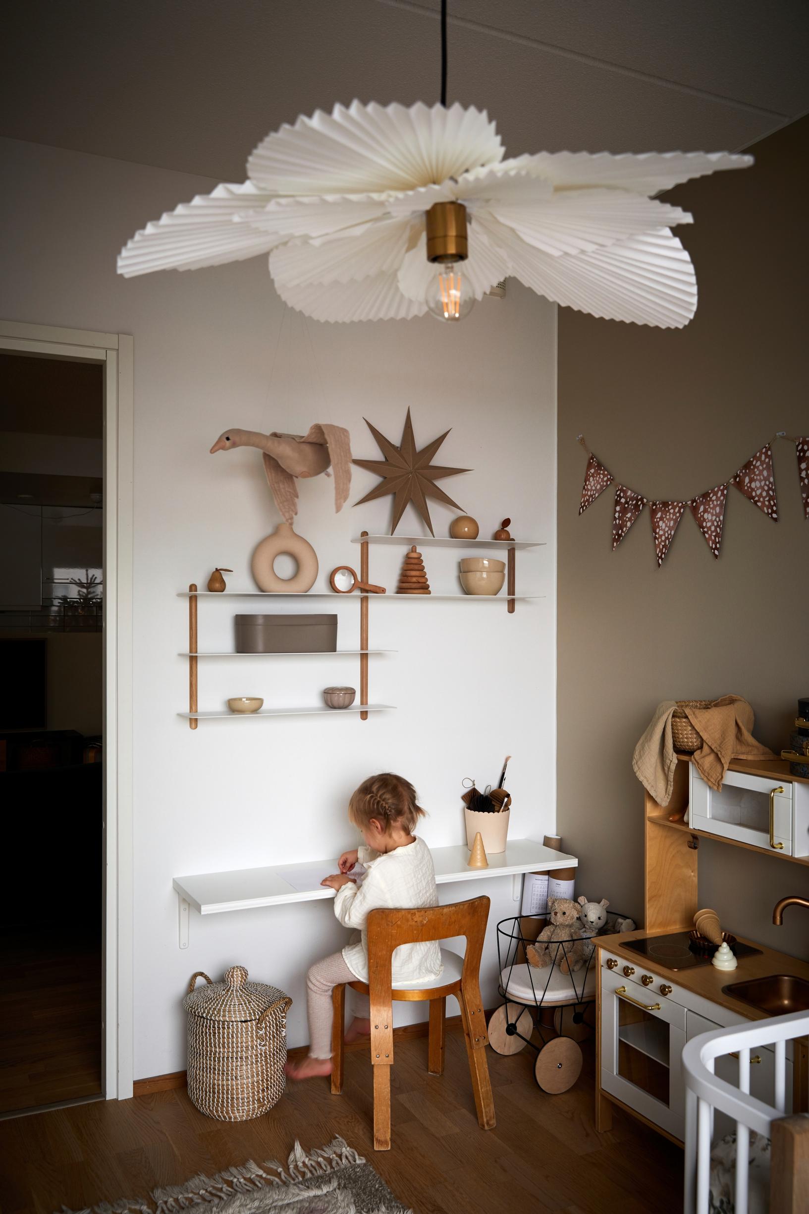 Lapsi piirtää lastenhuoneessa