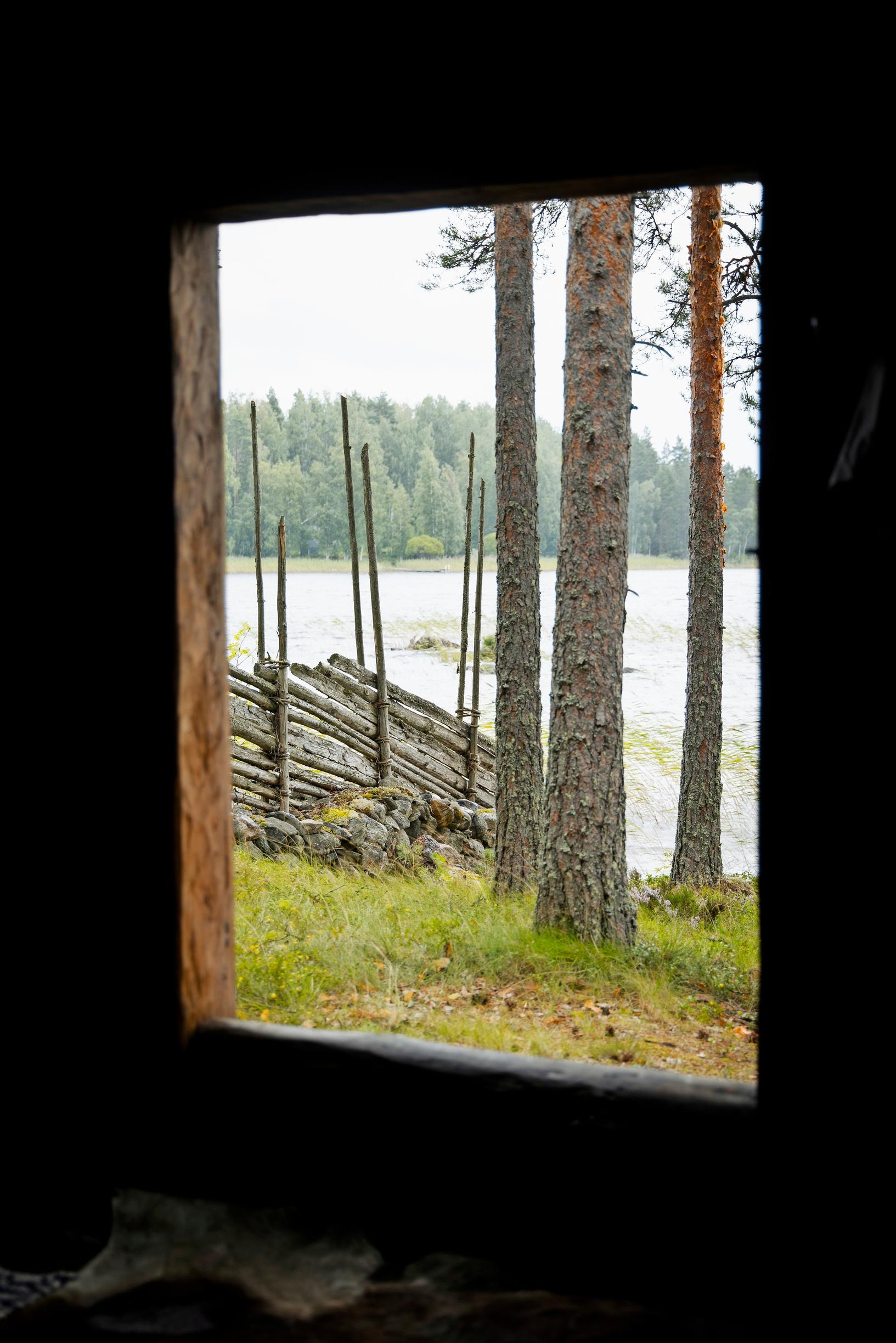 näkymä ulos savusaunasta järvelle, aitaa