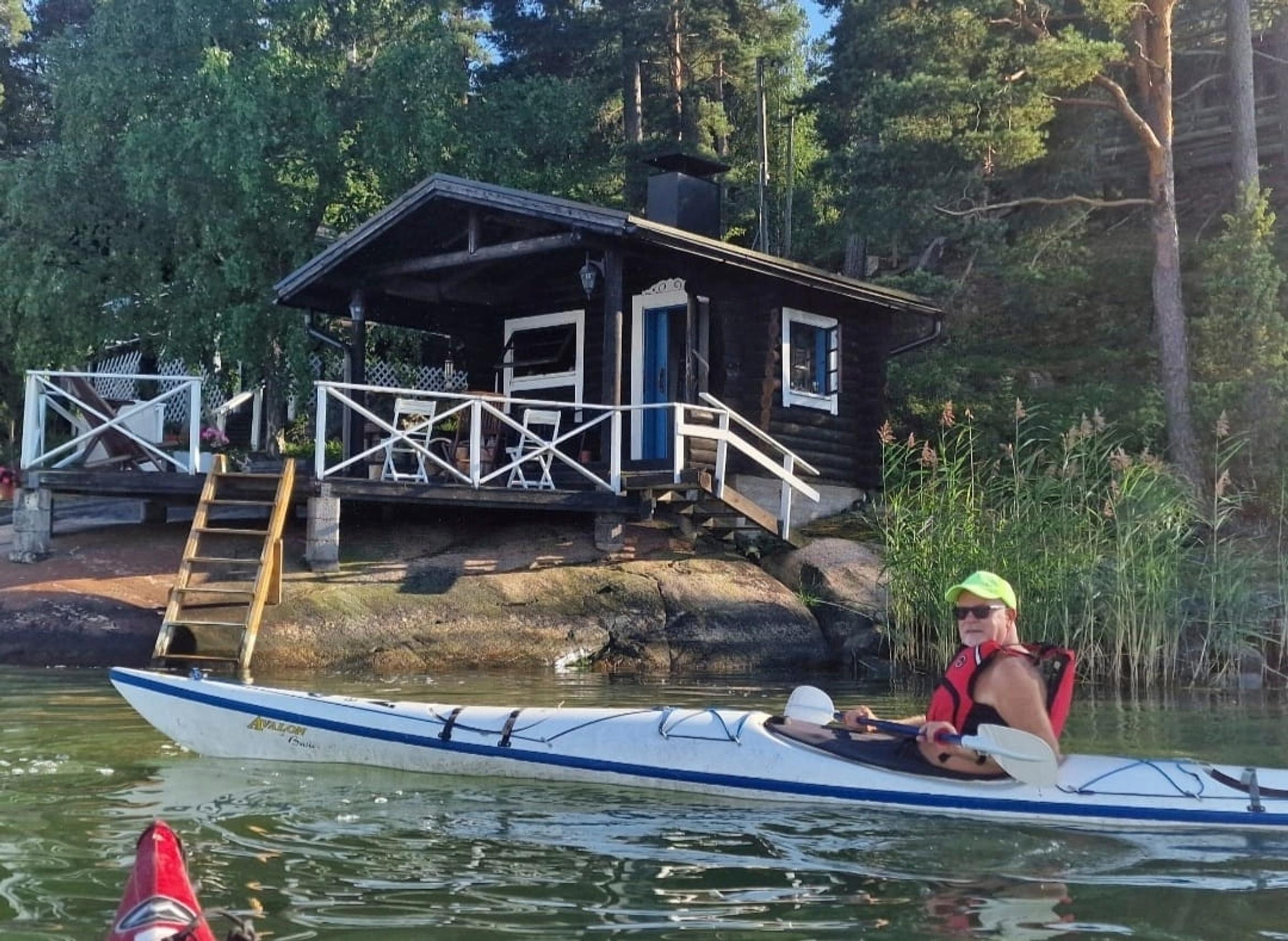 laulaja Petri Laaksonen melomassa, taustalla rantasauna