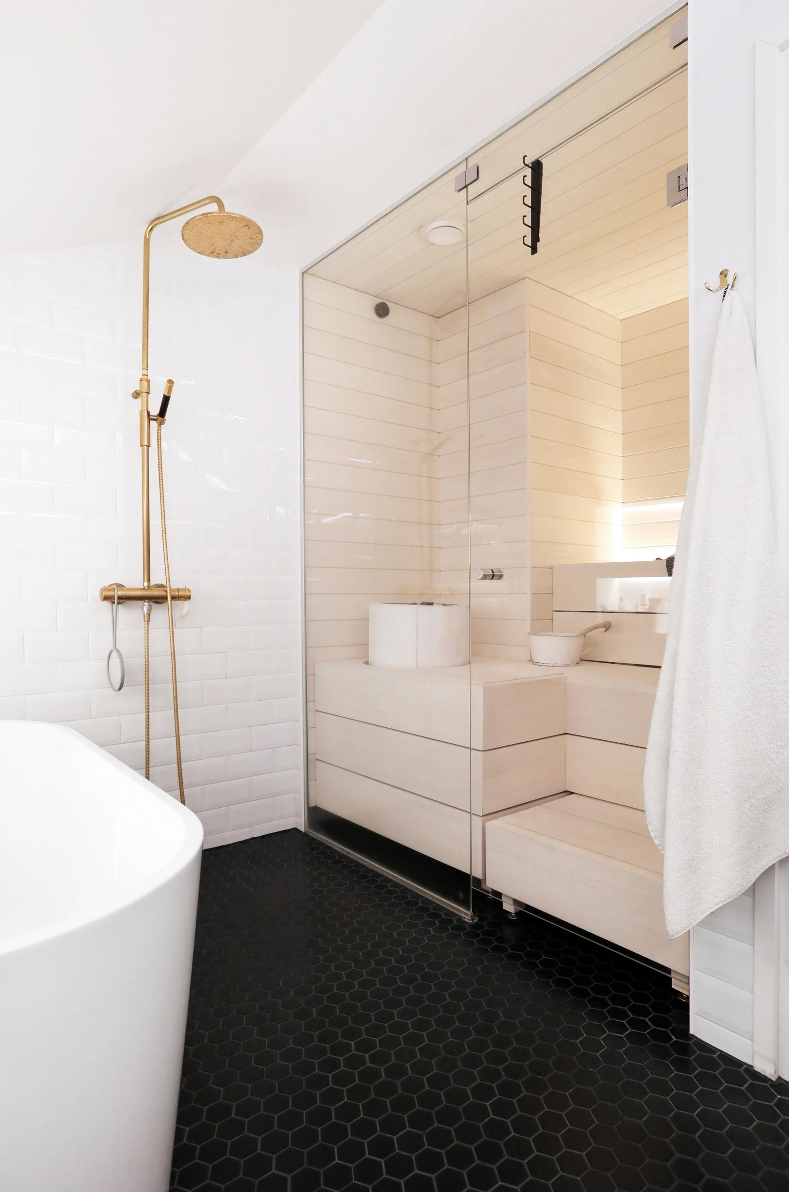 Vaalea, lasiseinäinen sauna avartaa kylpytilaa