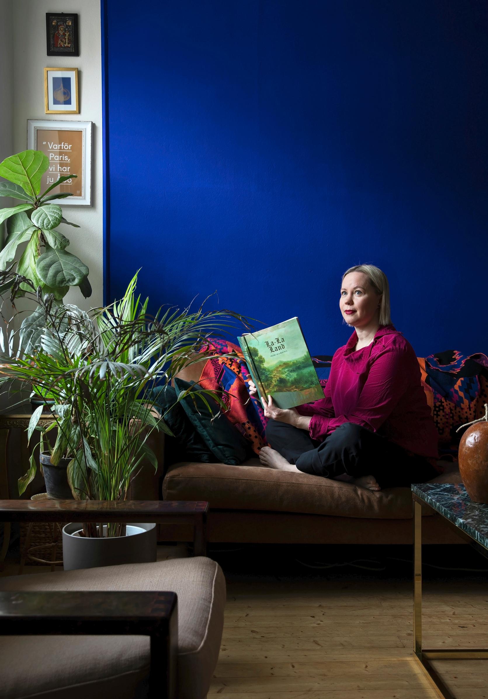 Erika kotinsa sohvalla, taustalla syvänsininen seinä