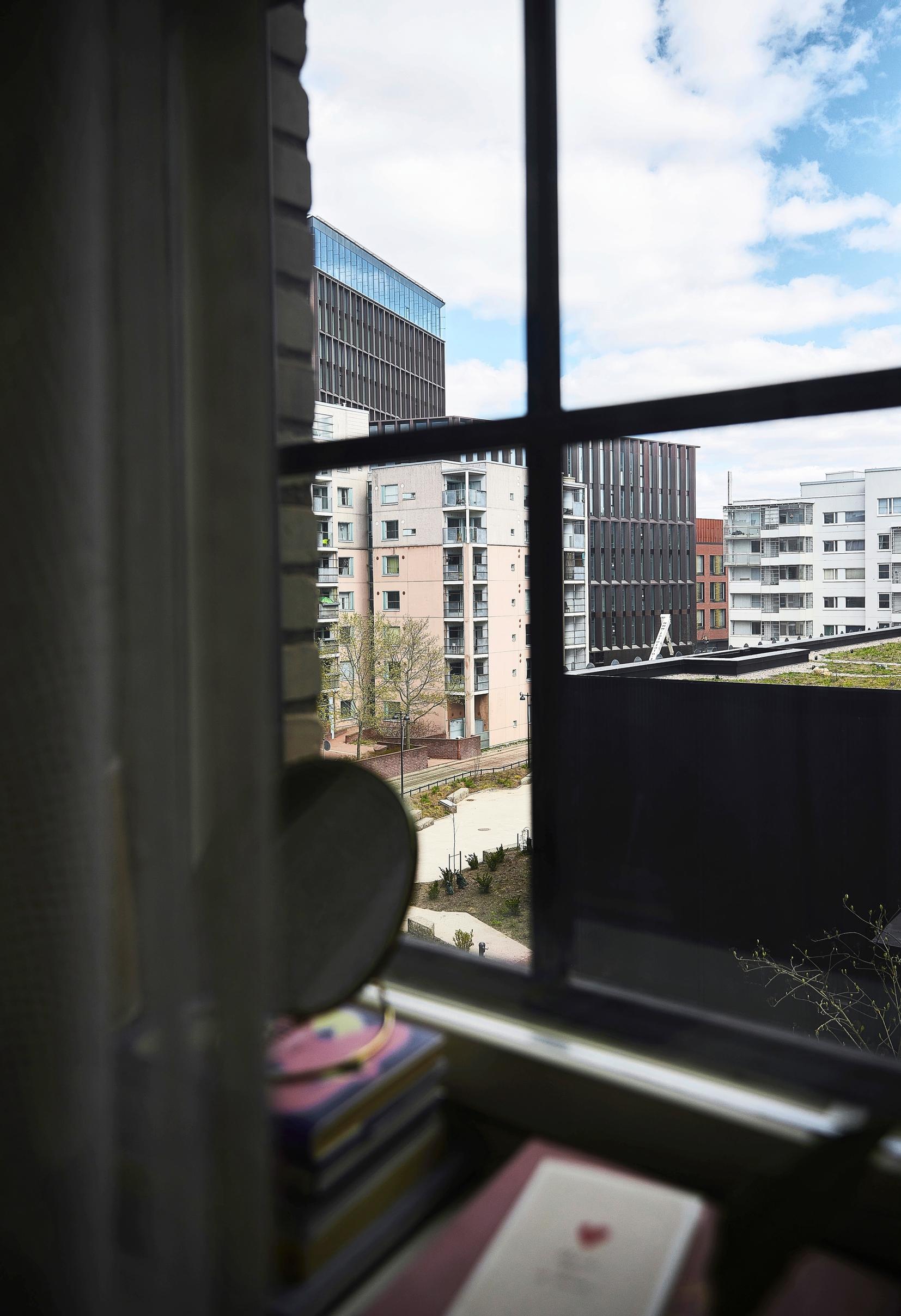 Ikkunoista näkyy kaupunkimaisema ja viherkatto.