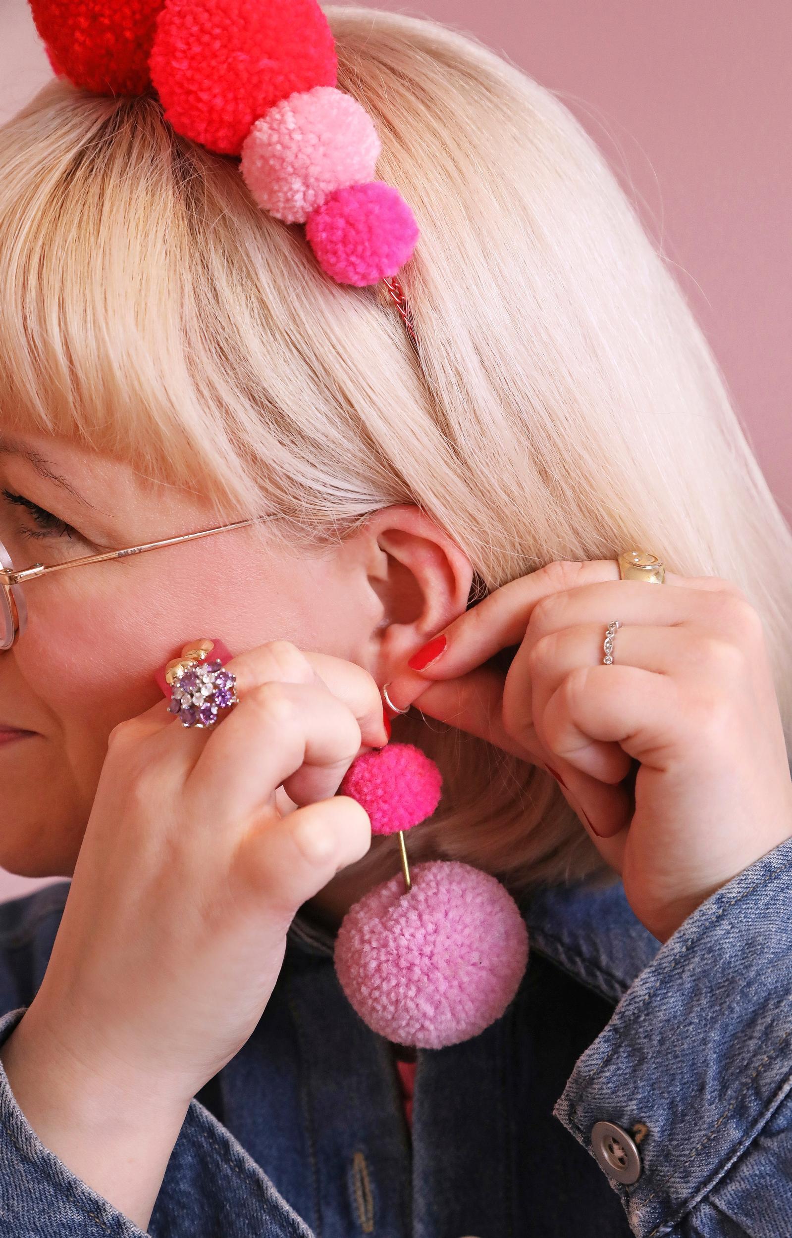 Marin korvissa pinkit pompom-korvikset