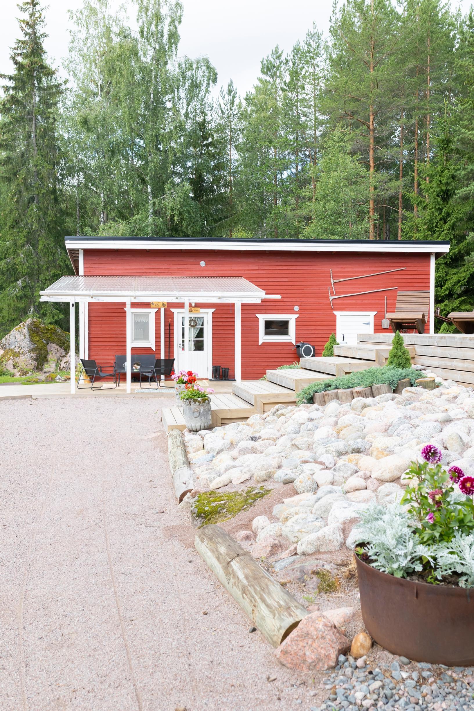 punavalkoinen rakennus, iso sorapiha, portaat terassille ja kiveystä