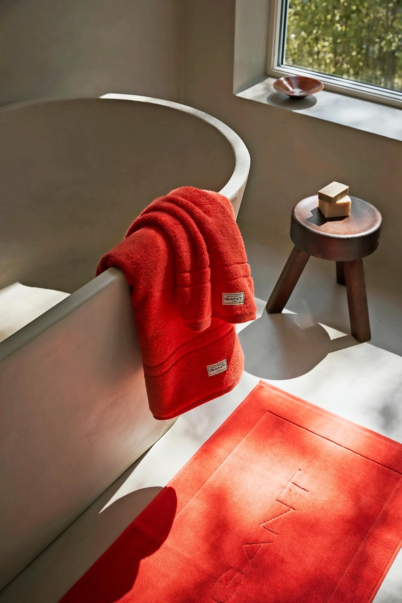 Gant Home Premium -sarjan punaiset pyyhkeet ammeen reunalla