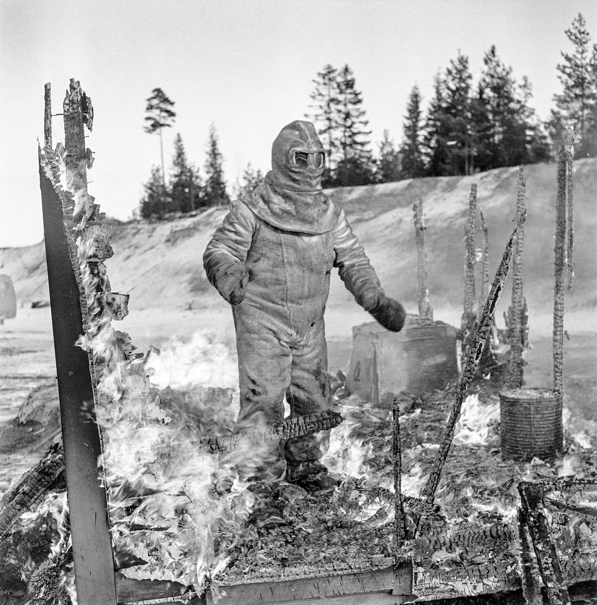 Apu-lehden reportteri Matti Jämsä kokeilee asbestista tehtyä palopukua vuonna 1957