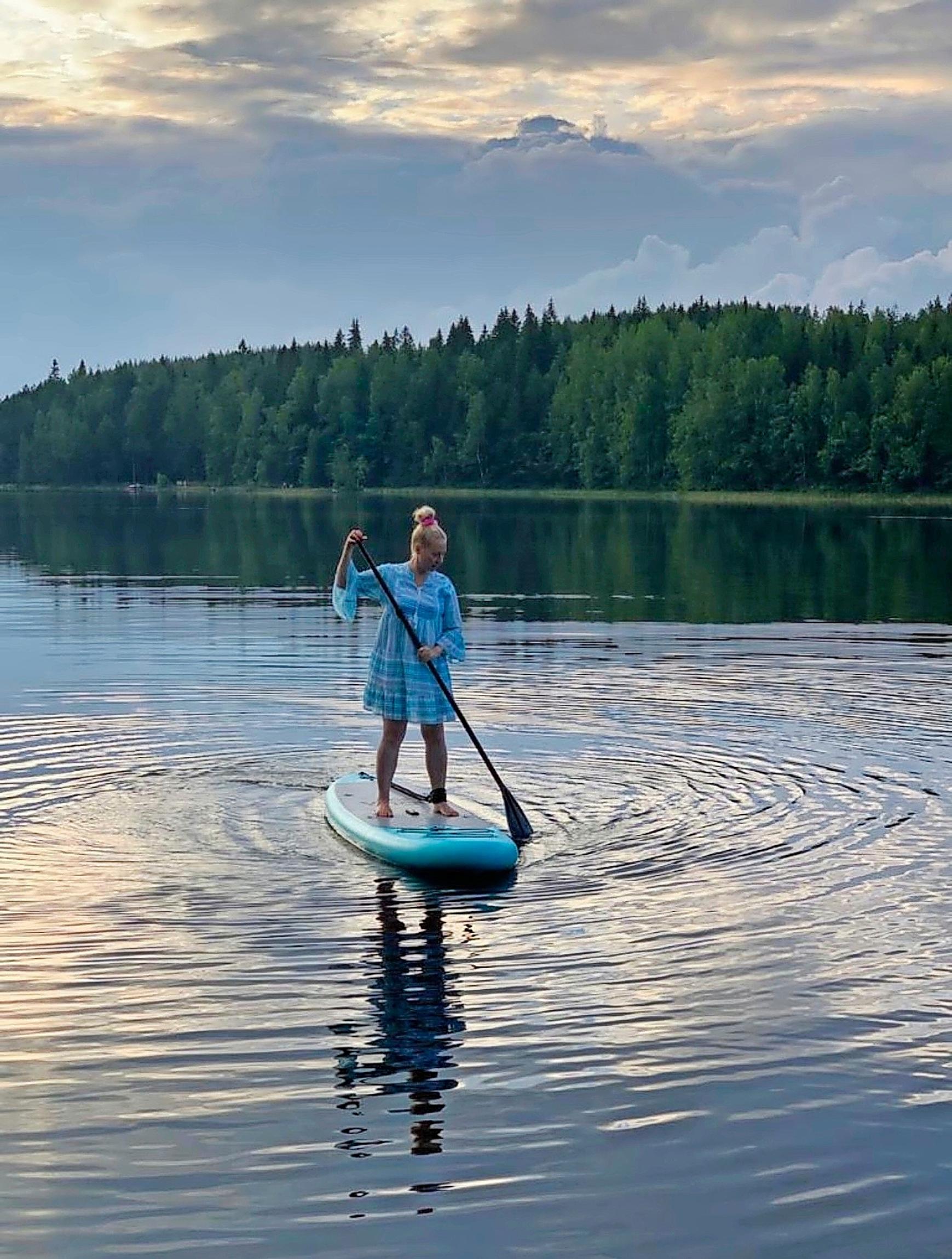 Näyttelijä Krisse Salminen suppilaudalla järvellä, vastarannalla metsää