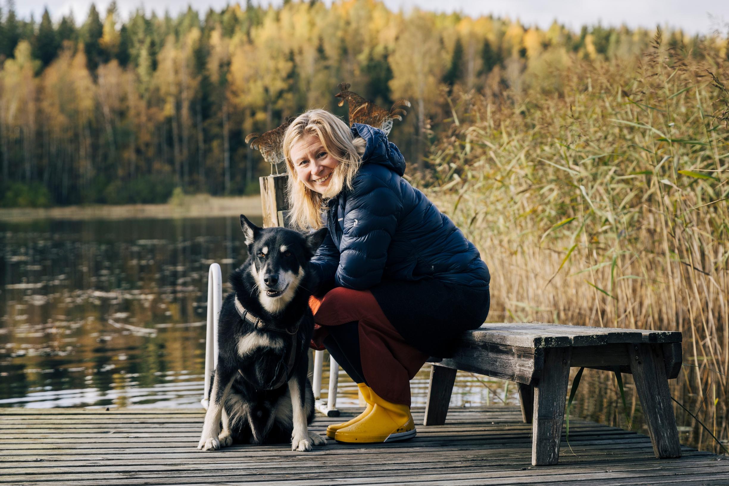 nainen ja koira istuvat laiturilla