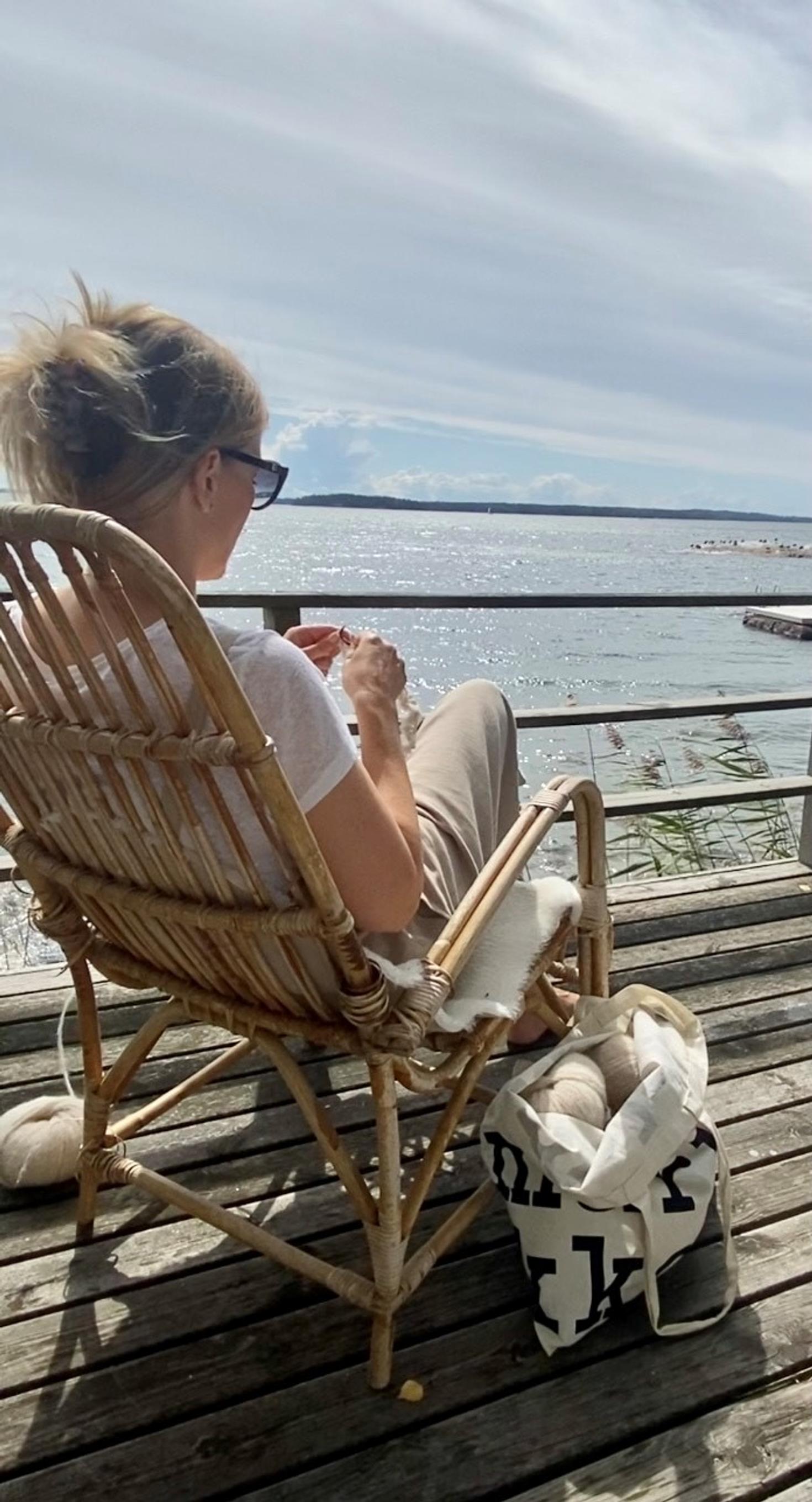 Suvi Cederberg ulkona terassilla neulomassa