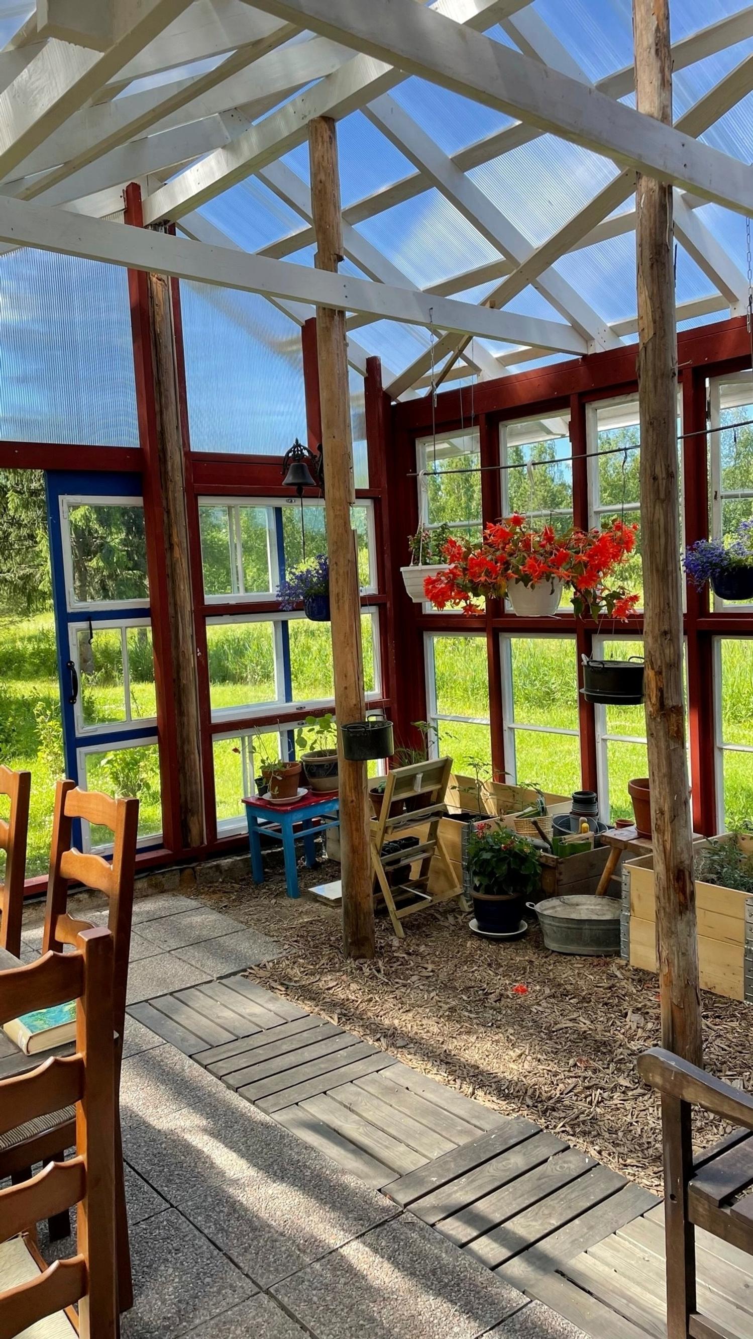 valmis pergola, jossa kesäkukkia ja laatat lattialla