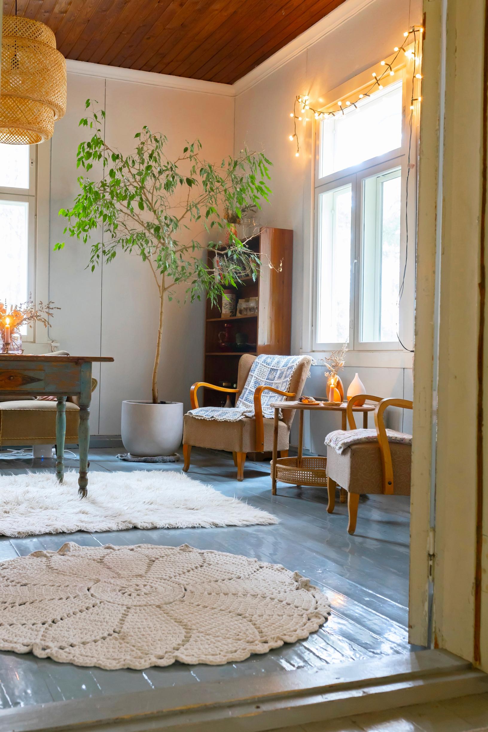 Puulattia, vanhoja nojatuoleja ja valkoisia mattoja.