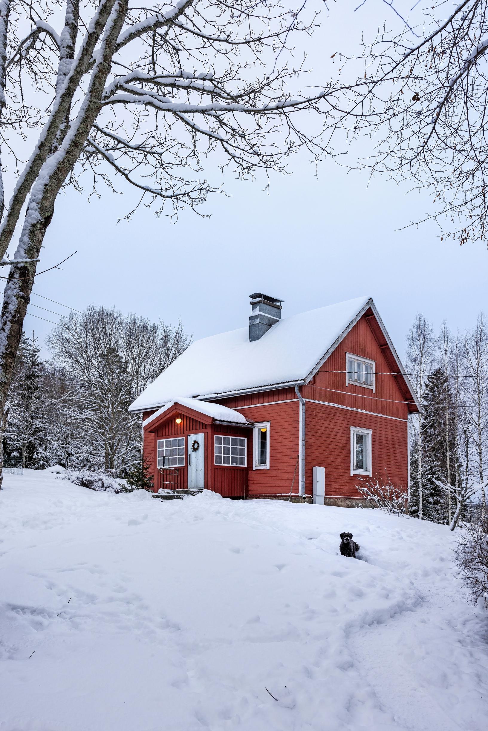 Elina ja Klaus Aallon perheen punainen mökki hangen keskellä
