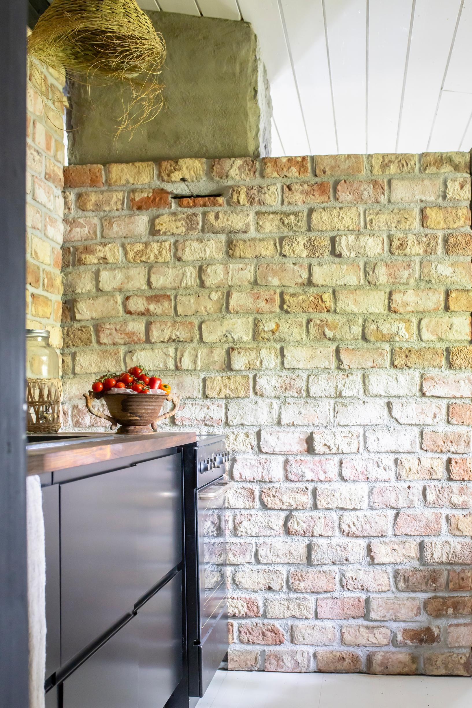 Remontoidun mökkikeittiön tiiliseinä