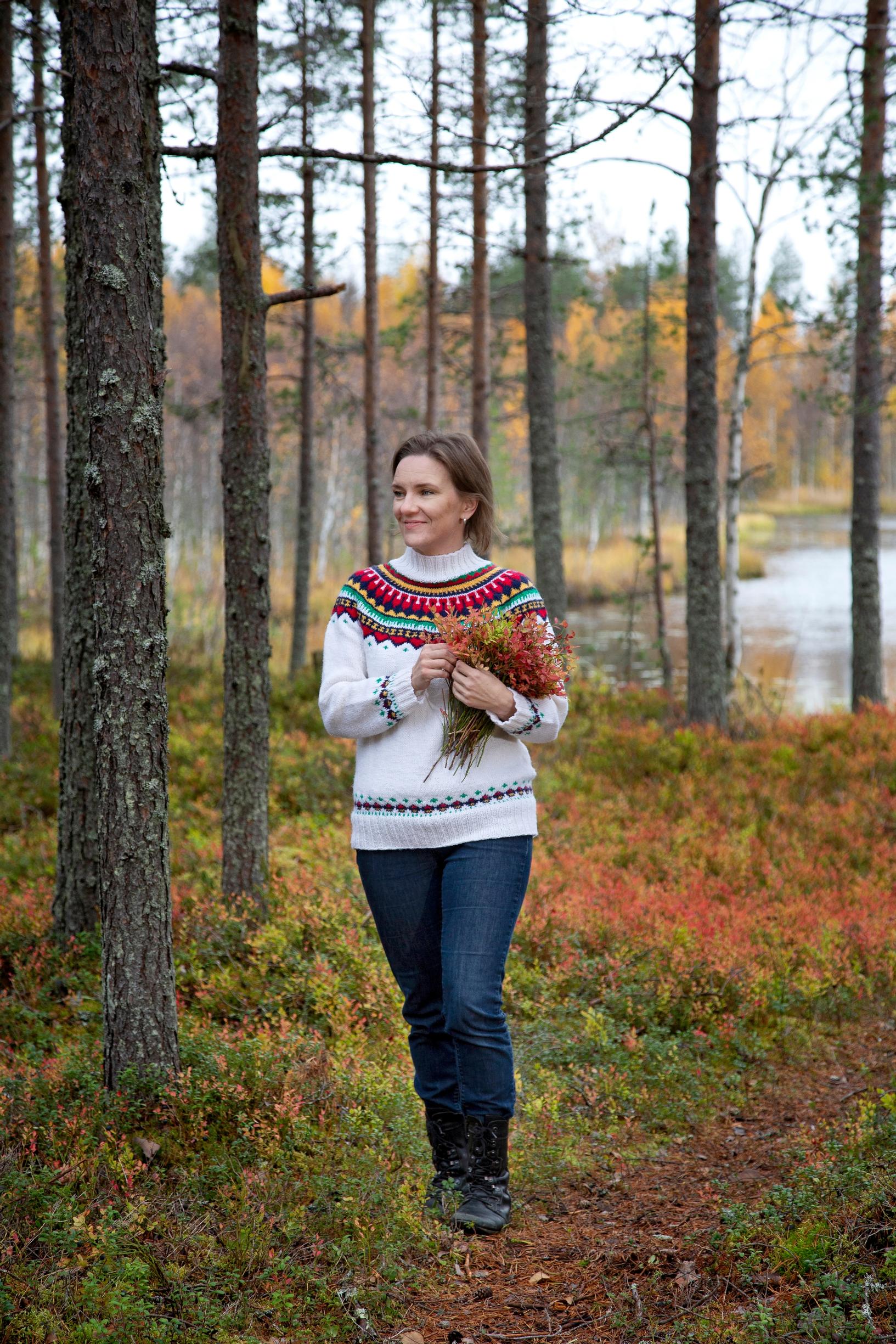 Nainen astelee ruskasävyisessä metsässä