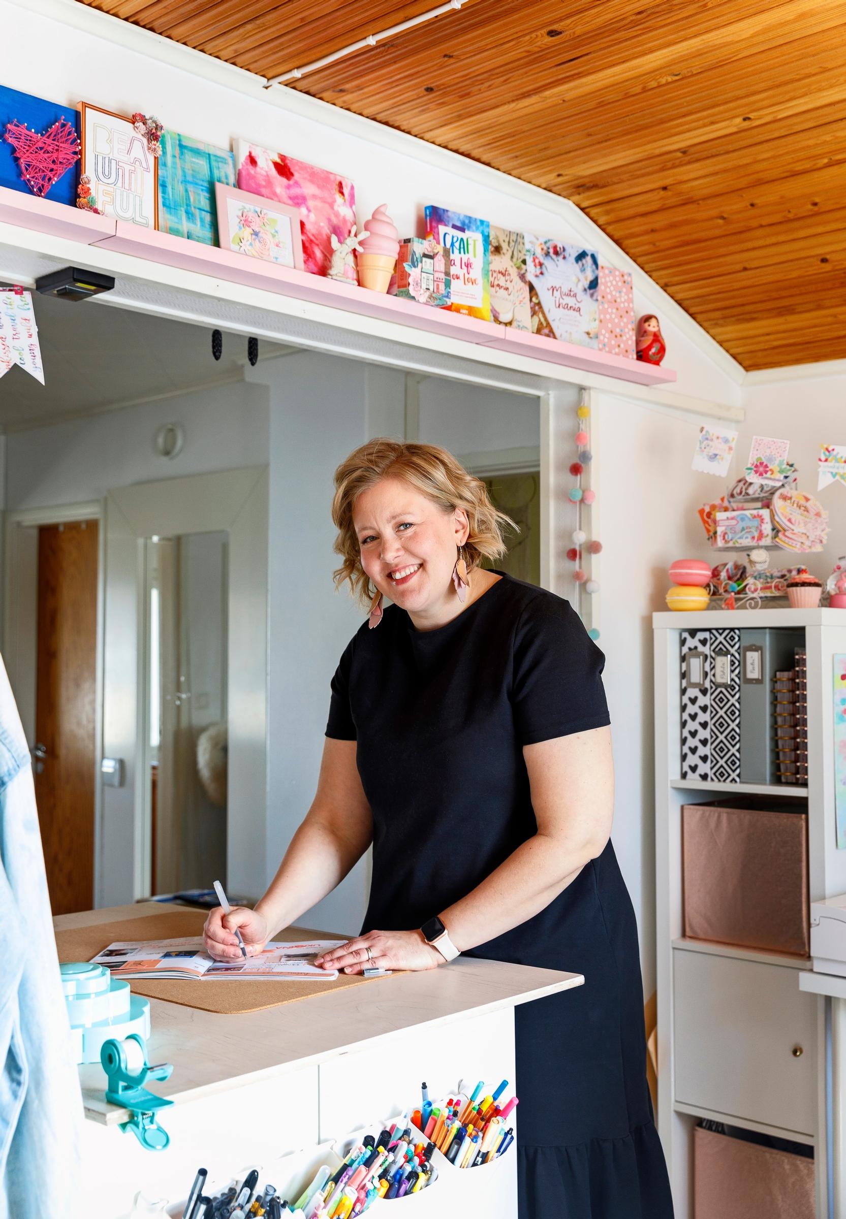 nainen askartelemassa pöydän ääressä