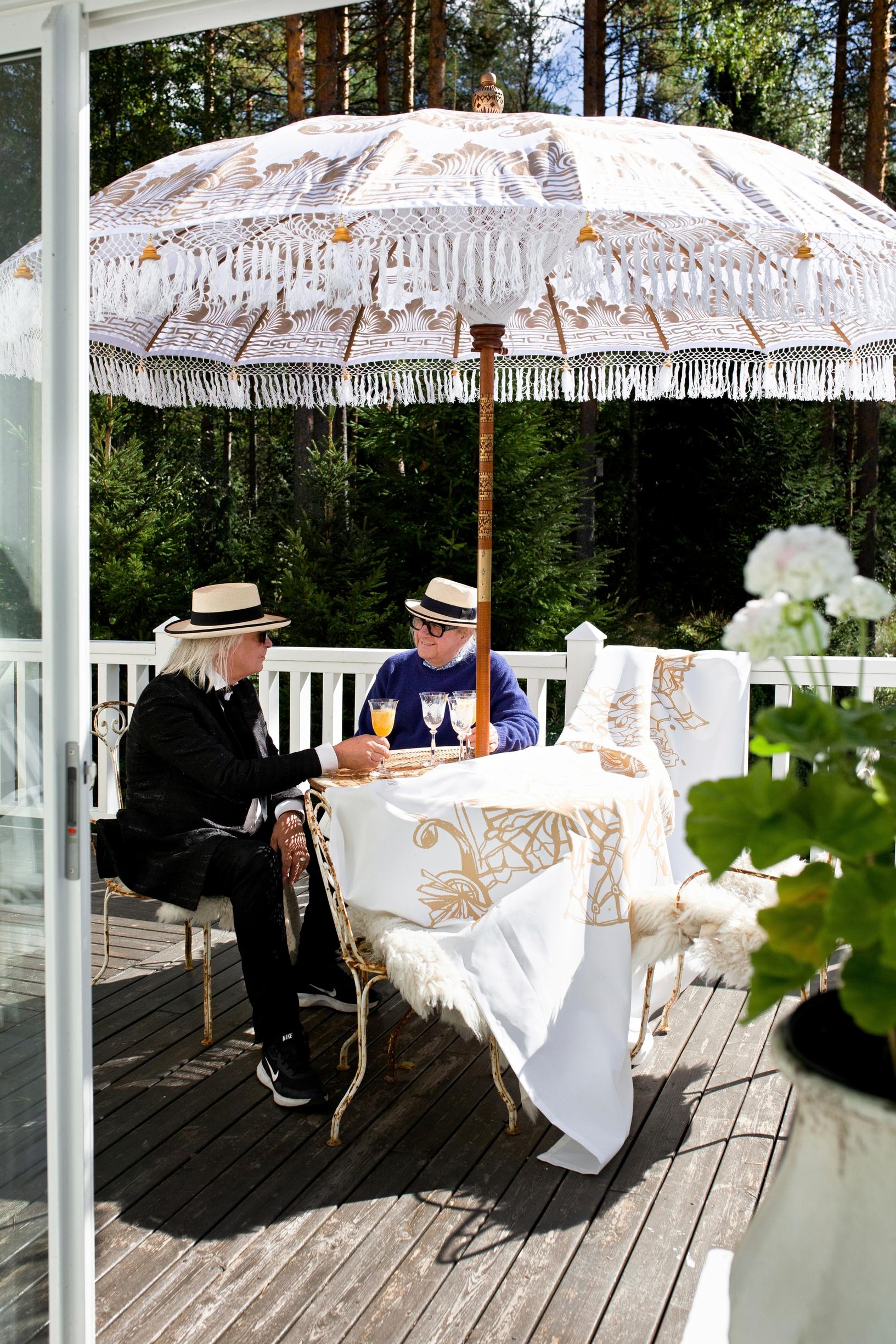 Jukka ja Matti terassilla aurinkovarjon alla