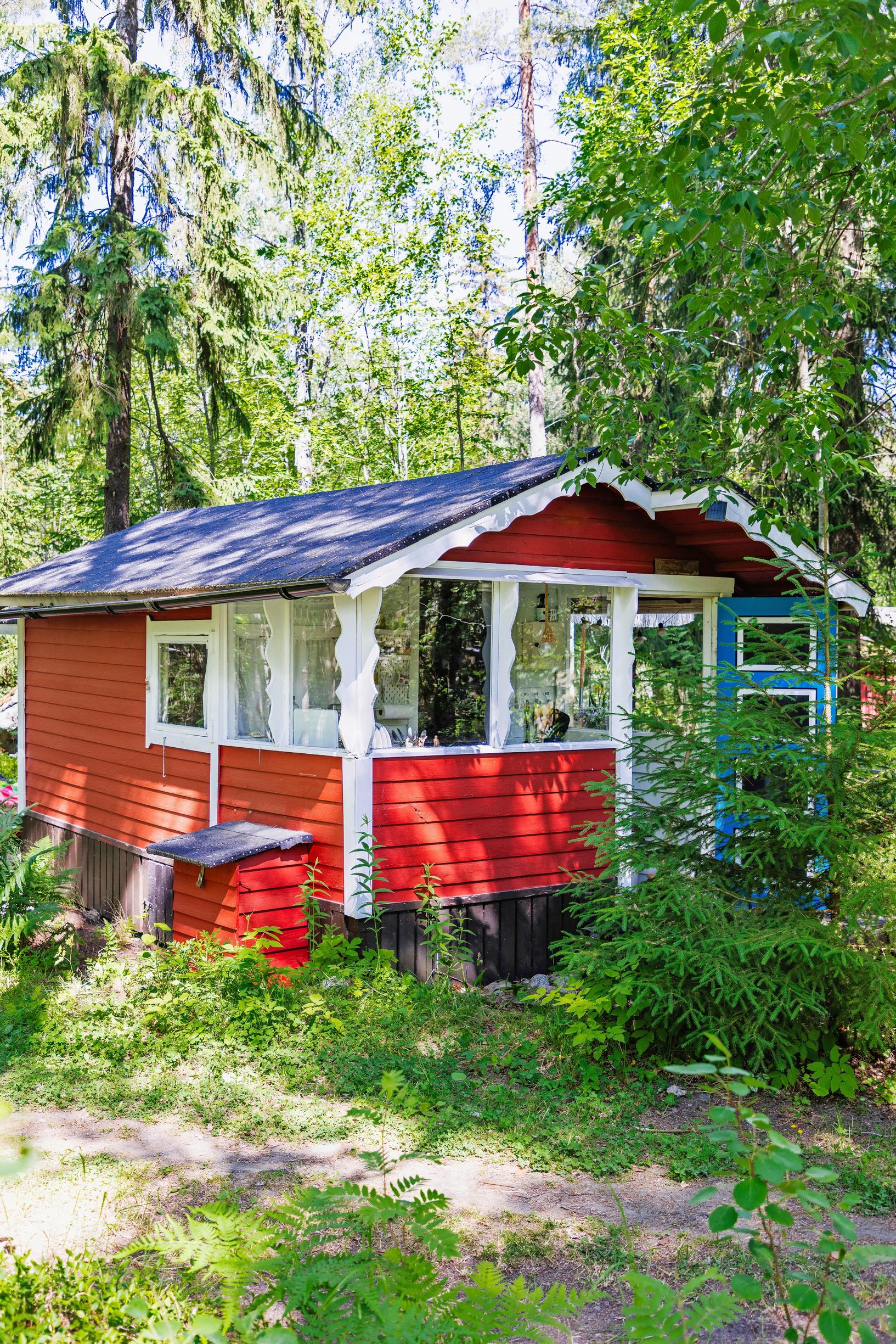 punainen kesämaja ja metsää