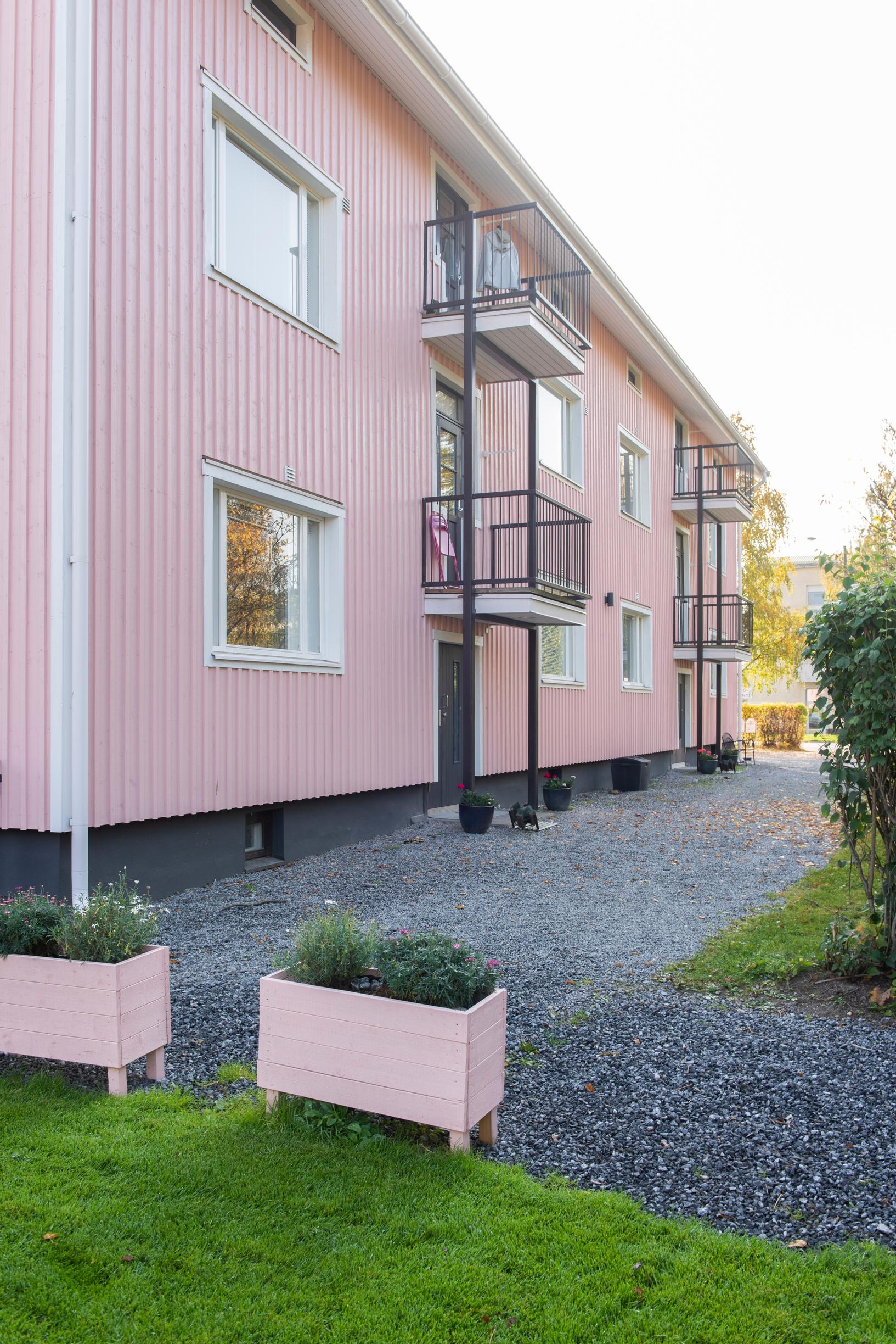 Vaaleanpunainen, puurakenteinen pienkerrostalo
