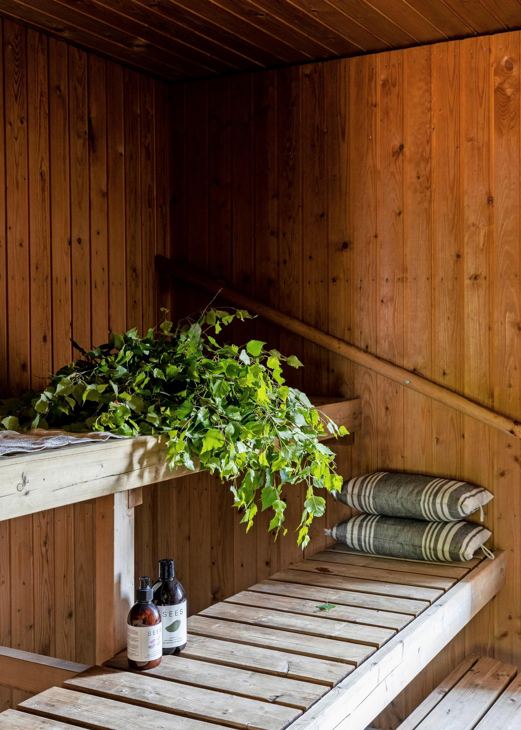 vihta, kaksi saunatyynyä ja löylytuoksuja lauteilla