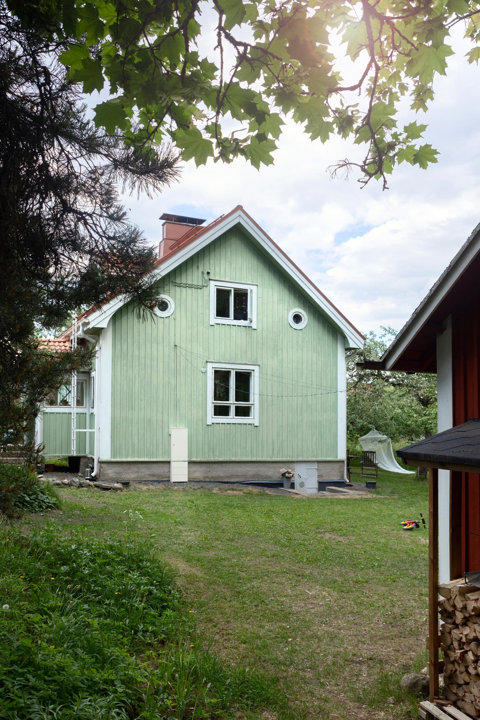 vihreä puutalo ja pihaa