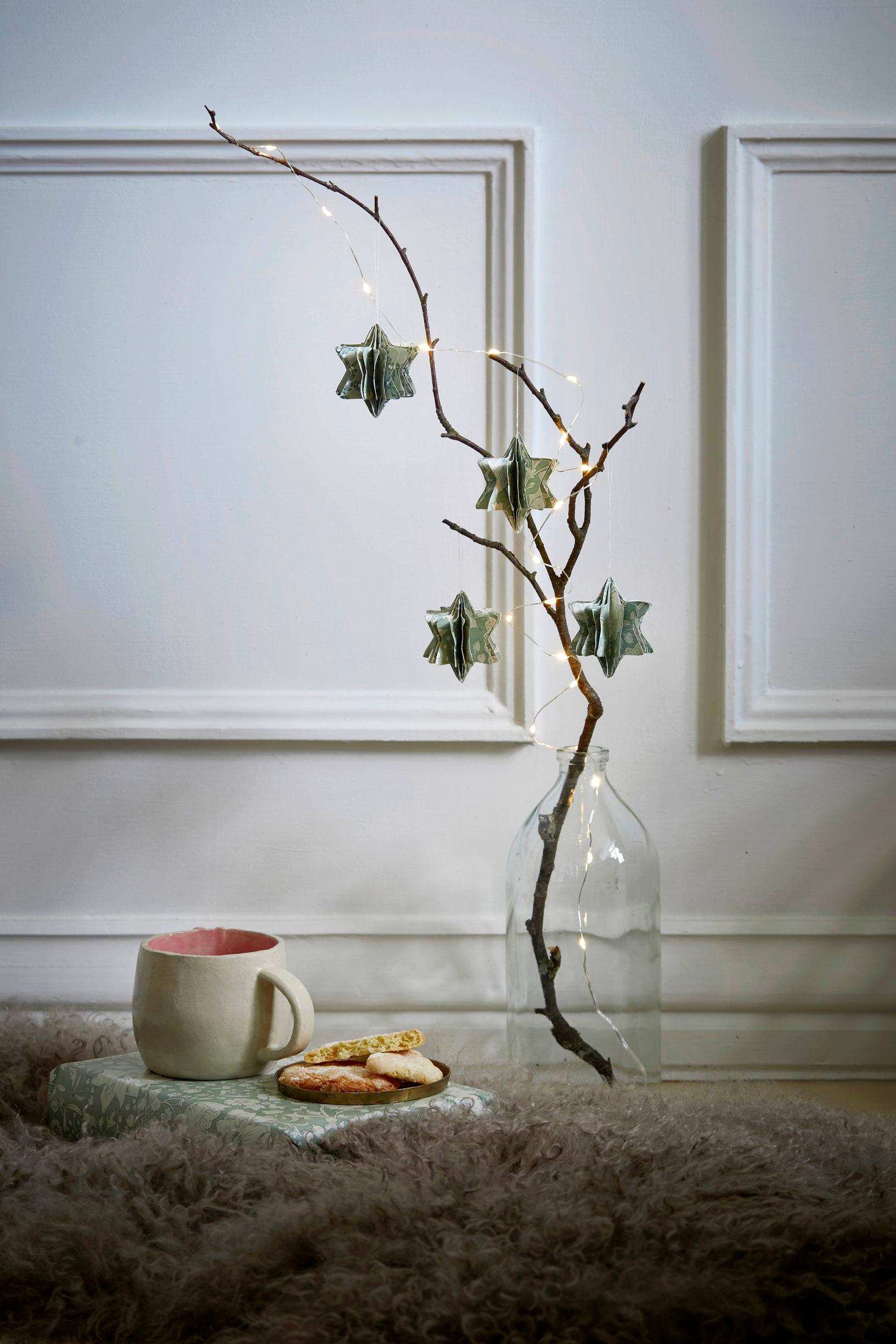 Tähtikoristeita ripustettuna oksaan.