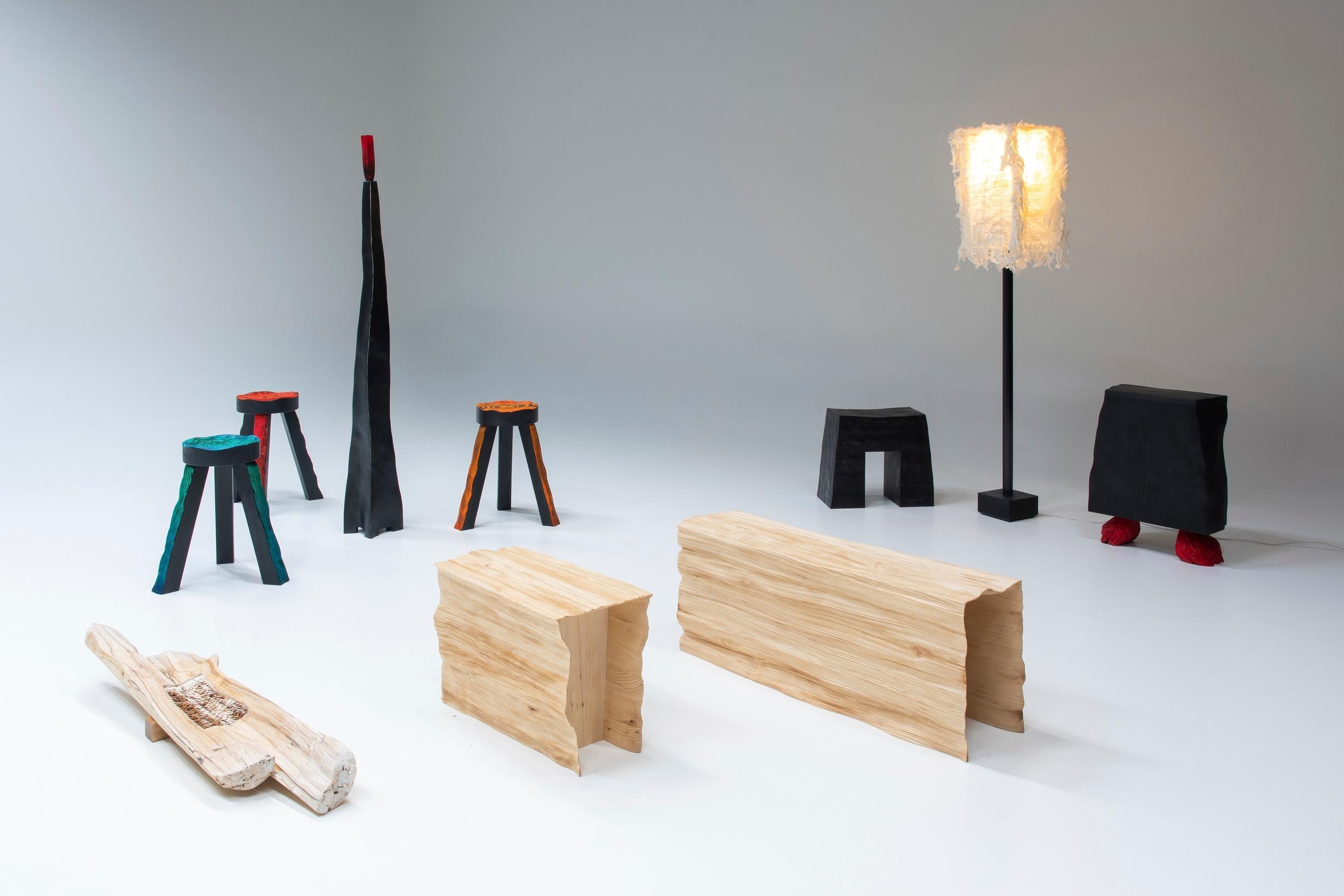 puisia erikoisia pöytiä, erivärisiä jakkaroita ja jalkalamppuja