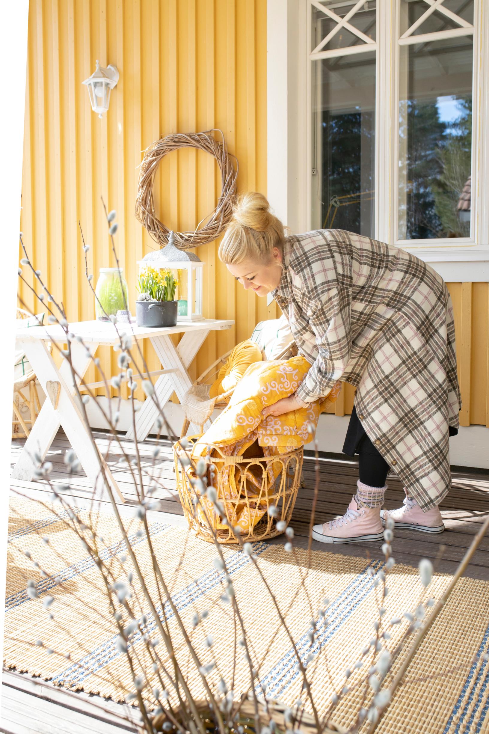 Anu asettelee pääsiäiskoristeita pihalle.