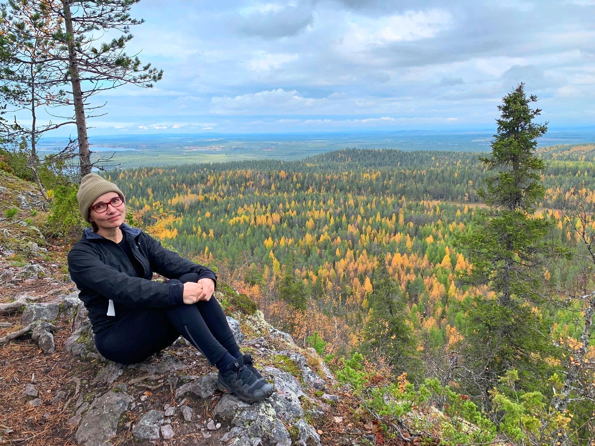 nainen istuu kalliolla