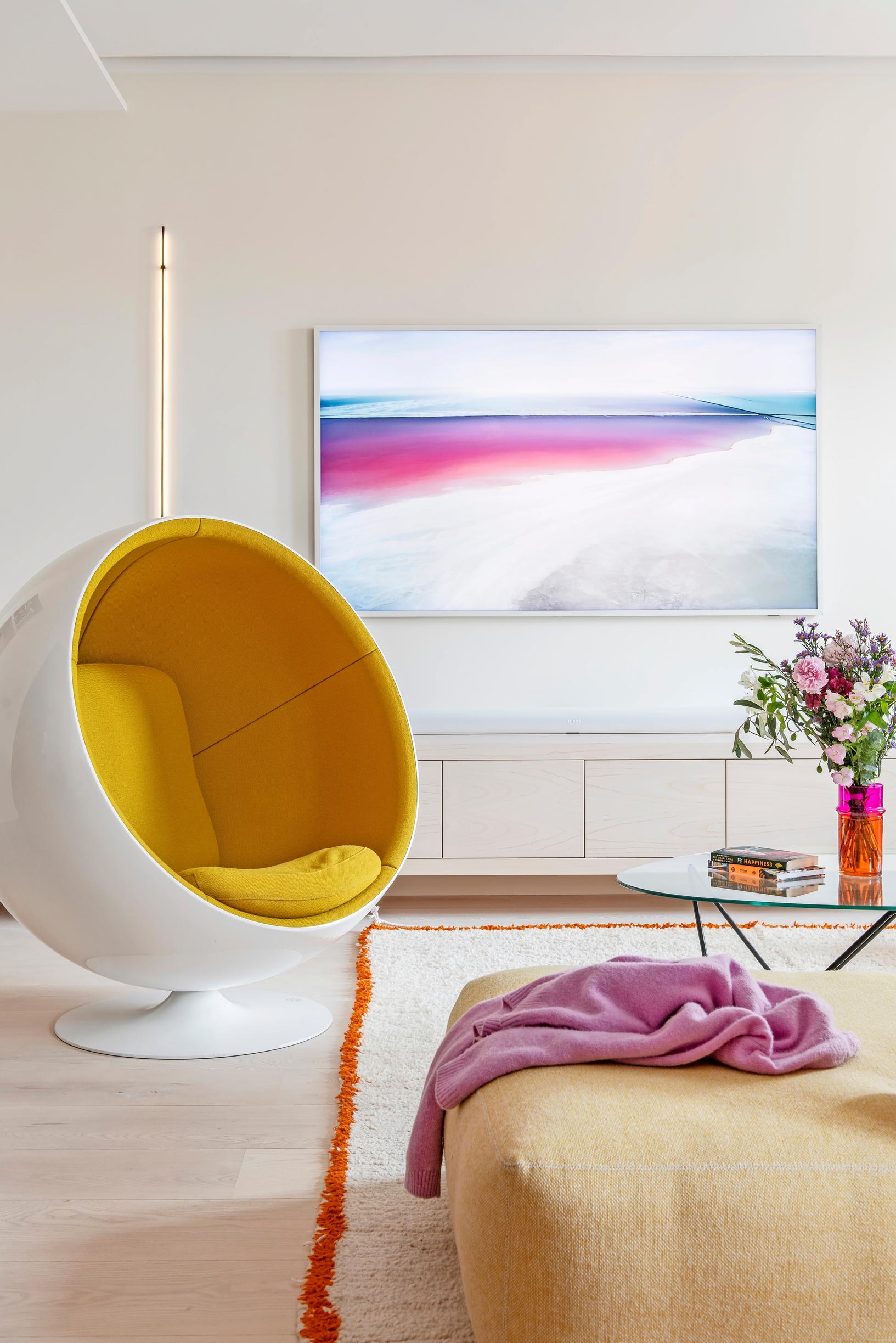 Eero Aarnion suunnittelema Pallotuoli ja tv-taso sekä iso taulu-tv olohuoneessa
