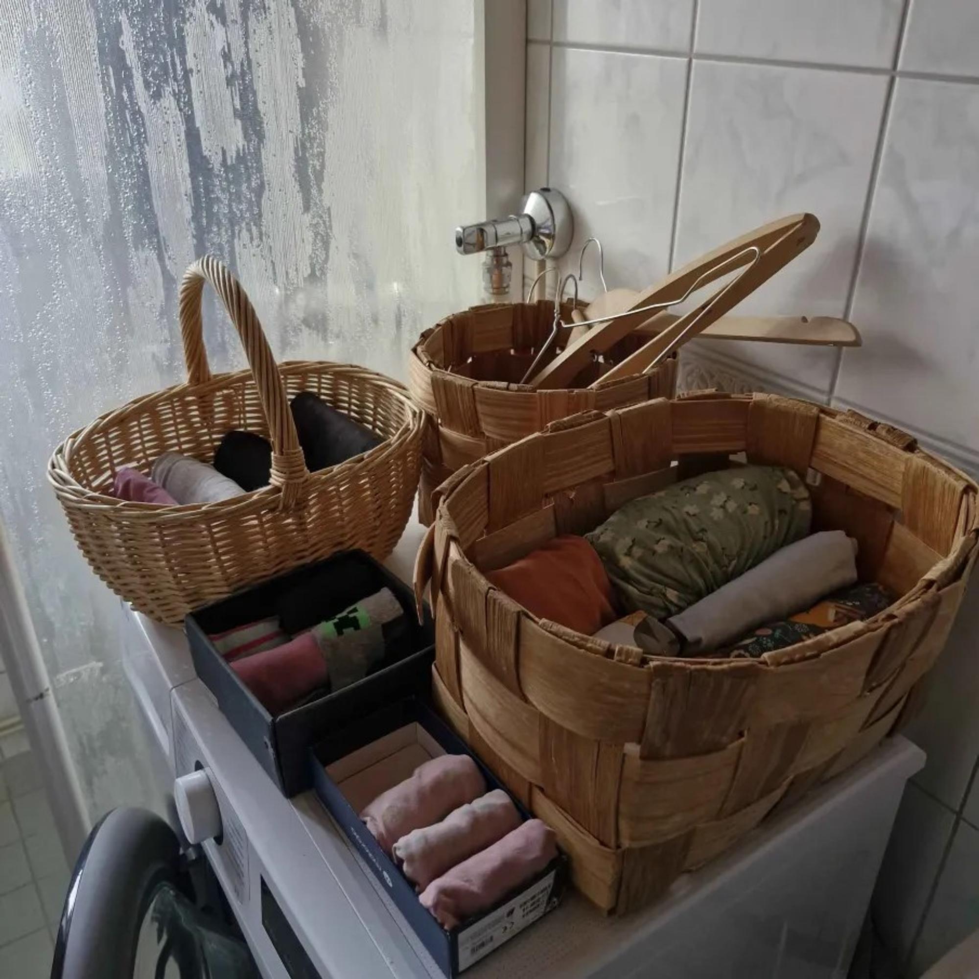kolme koria ja kaksi pientä laatikkoa pesukoneen päällä