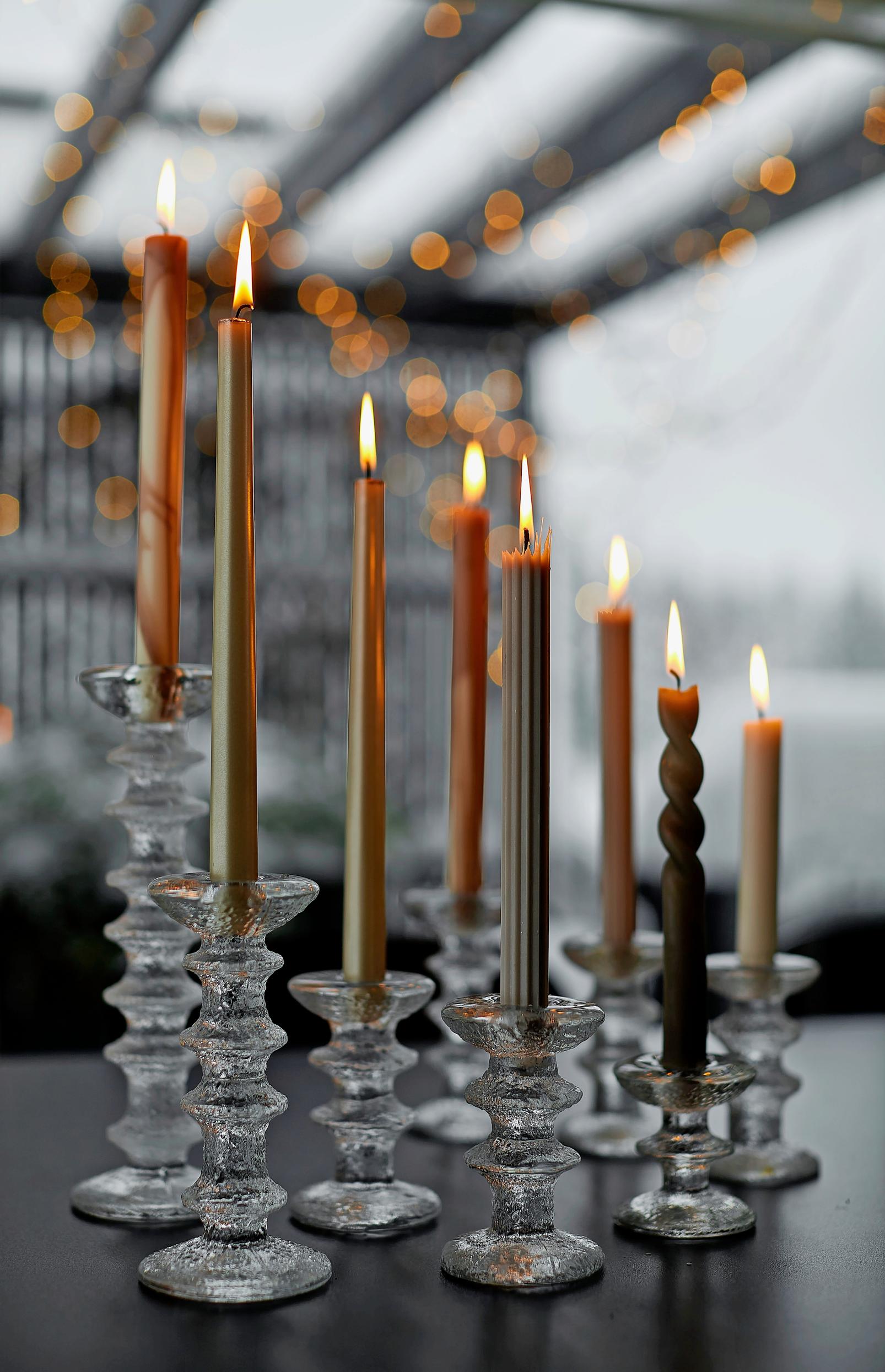 Ryhmä Festivo-kynttilänjalkoja pöydällä.