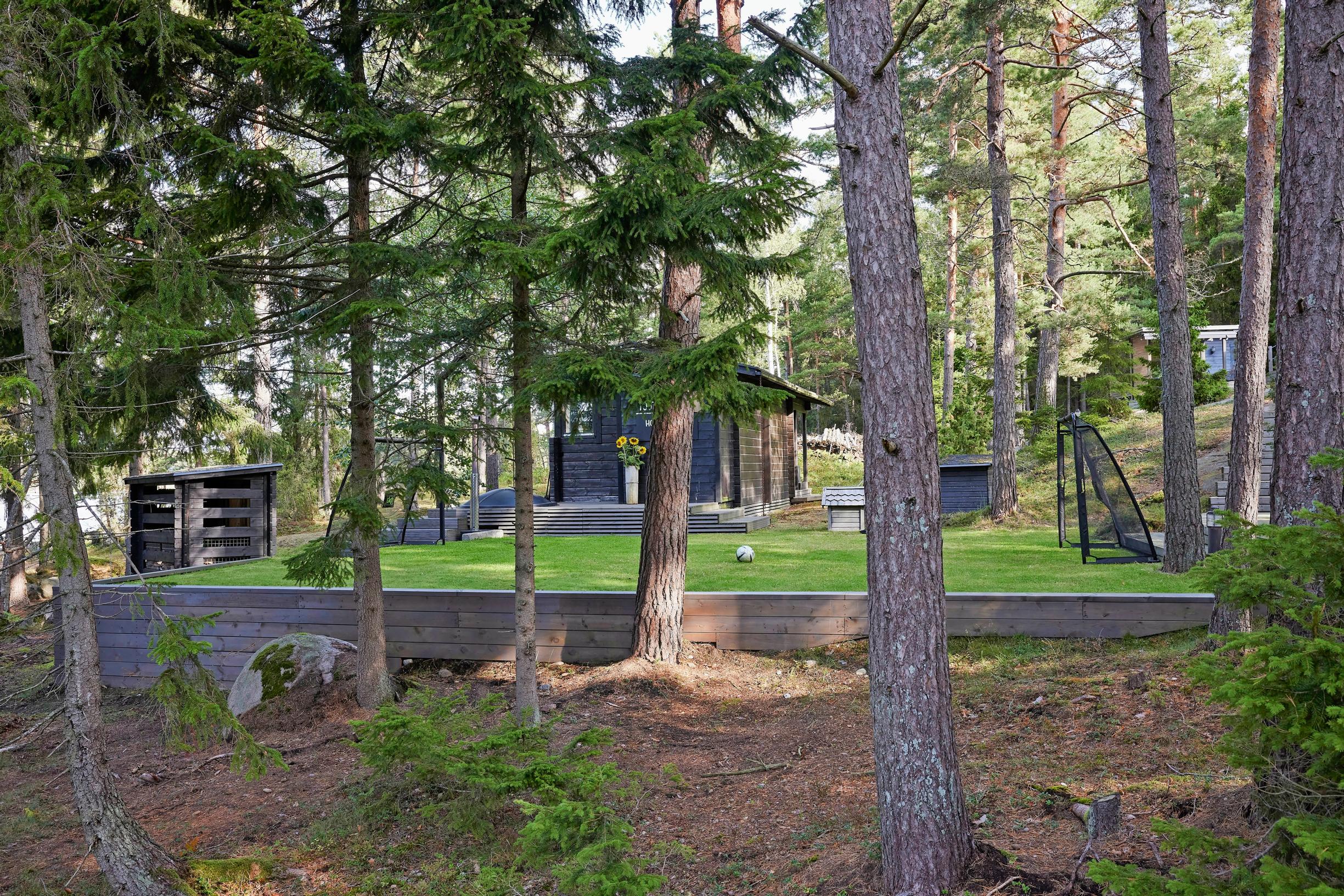 jalkapallokenttä mökillä metsän keskellä ja tummia rakennuksia