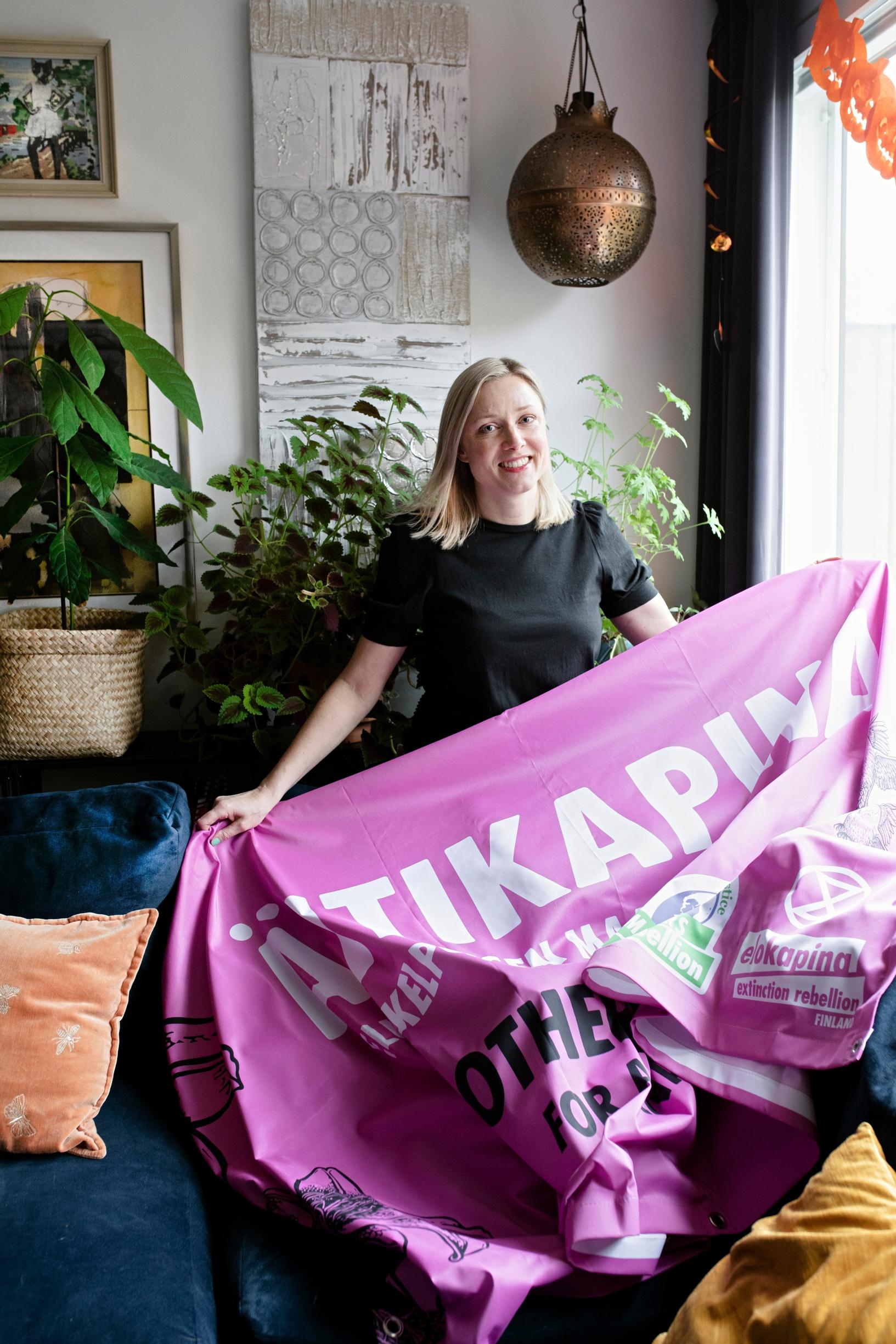 nainen pitää käsissään banderollia, jossa lukee Äitikapina