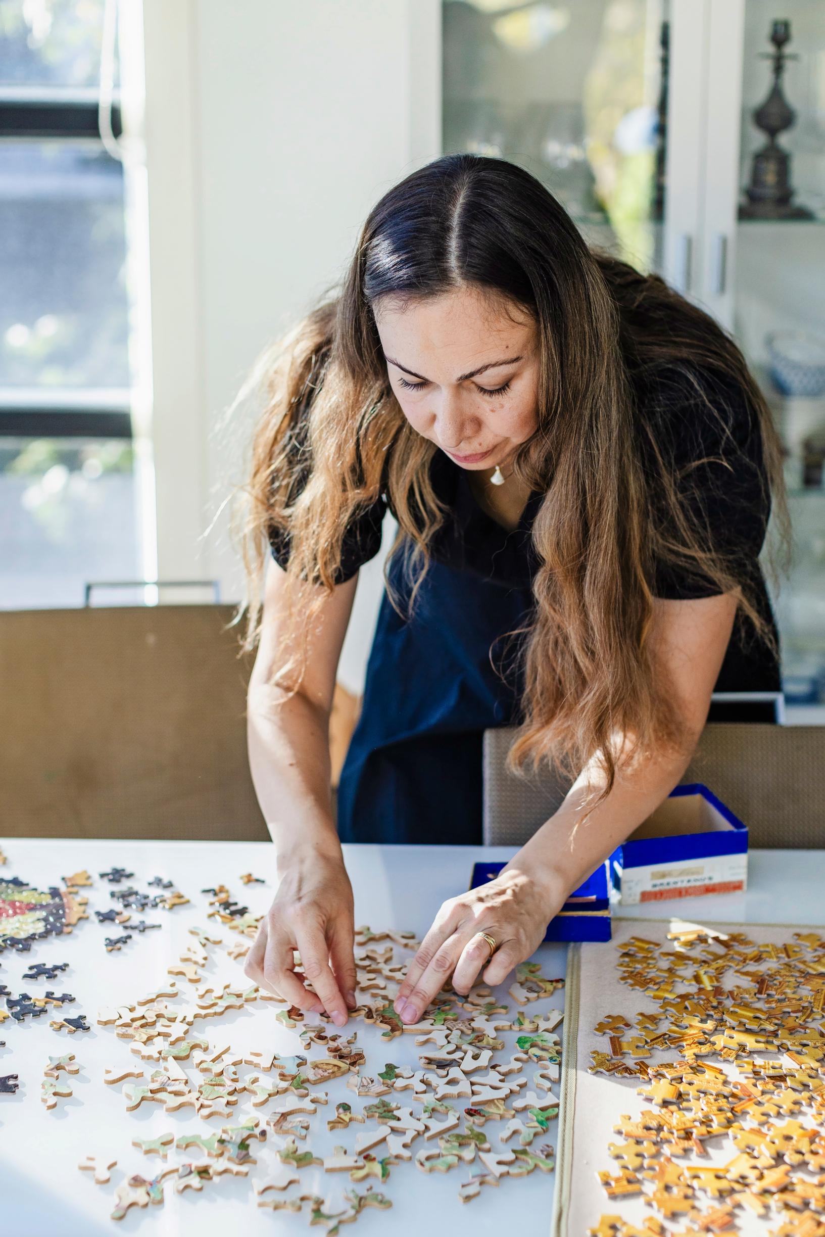 Kuvassa palapeliharrastaja Kira Rainvuori tekemässä palapeliä. 