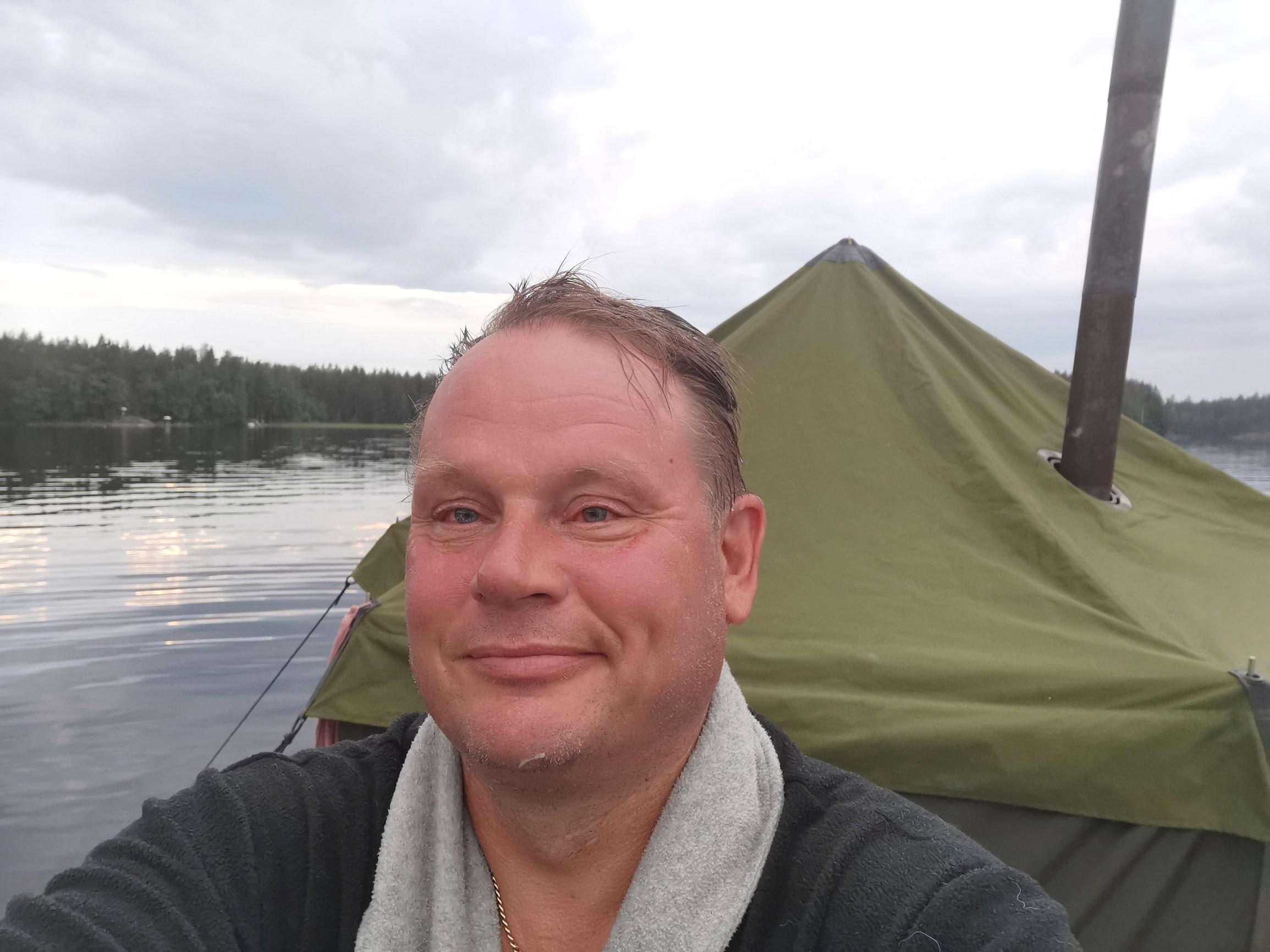 Markus Heiman kasvot punaisena saunalautan edessä järvellä