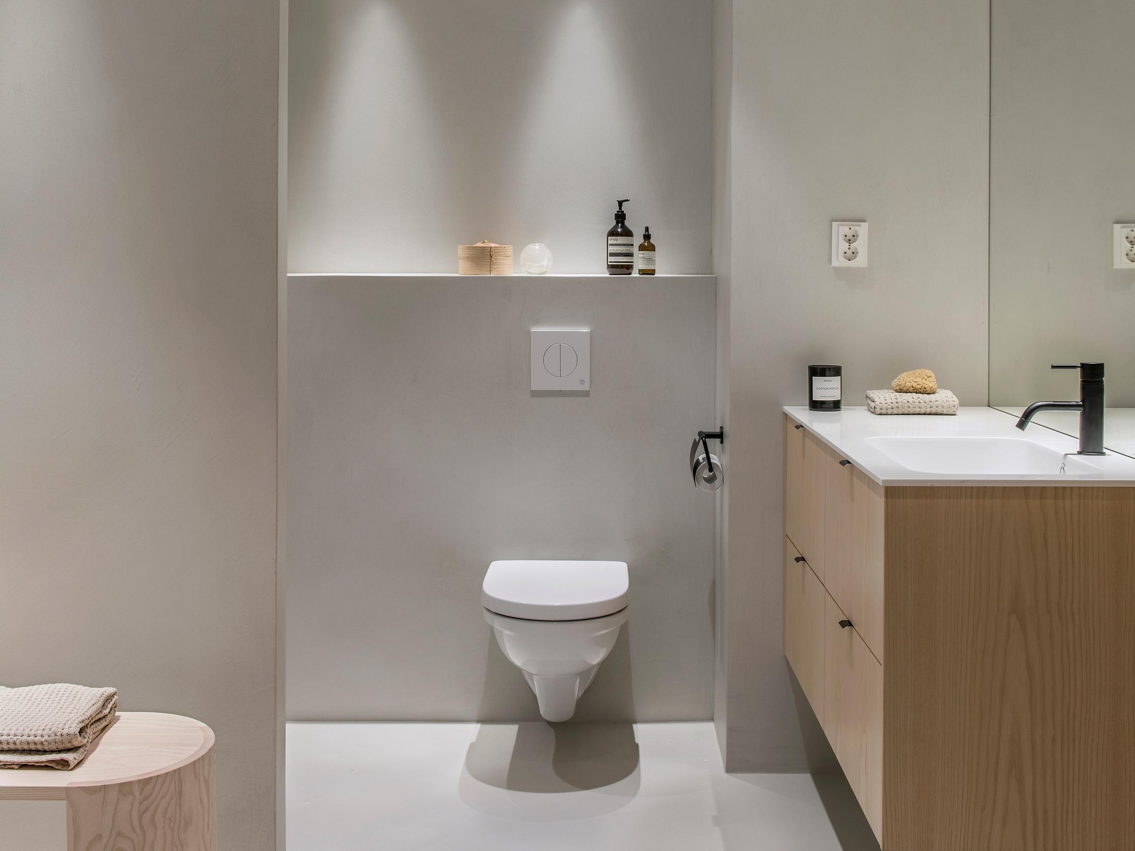 Saumaton kokonaisuus! Lapsiperheen minimalistinen kylpyhuone toteutettiin mikrosementillä ja luonnonväreillä