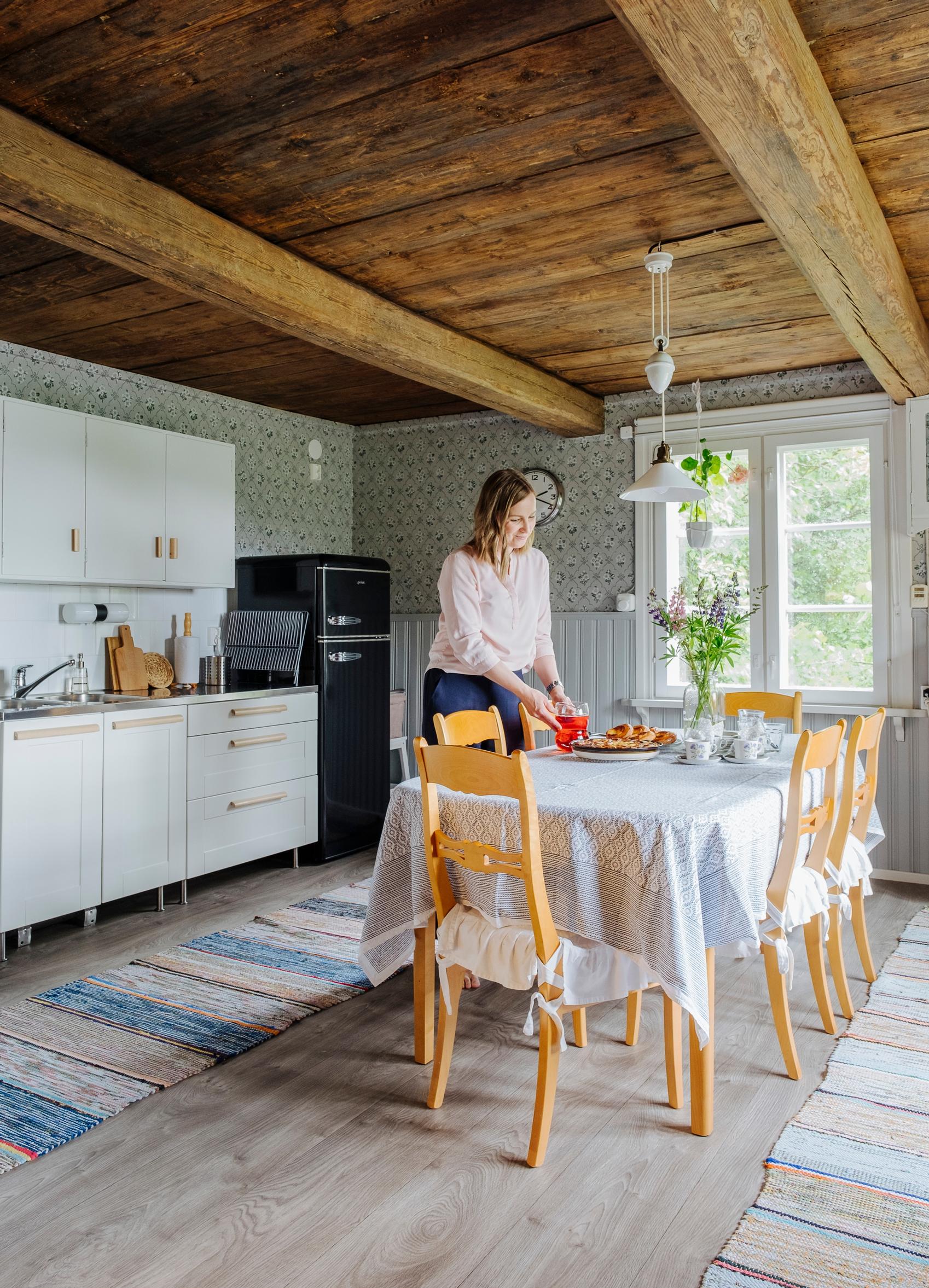 Sanna kattaa pöytää tuvassa