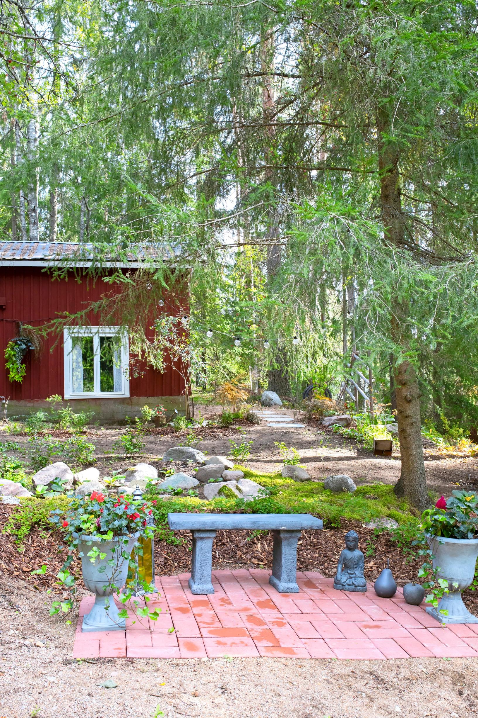 Puoliympyrän muotoinen kiveys ja ruukkuistutuksia