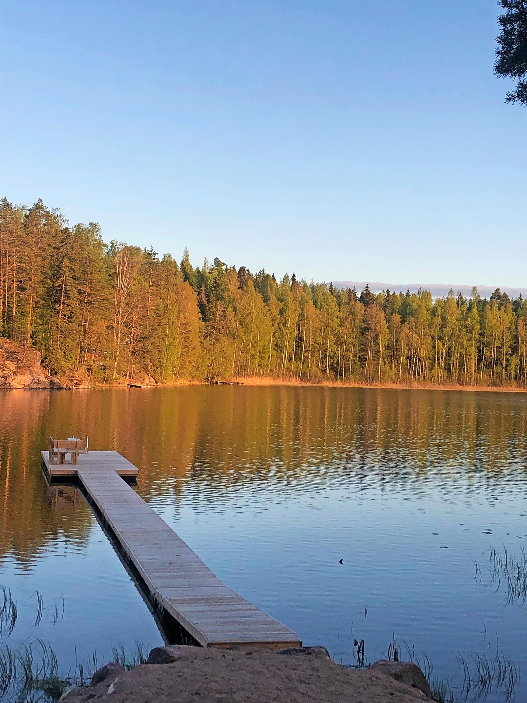 pitkä laituri ja vastarannalla metsä laskevan auringon valossa