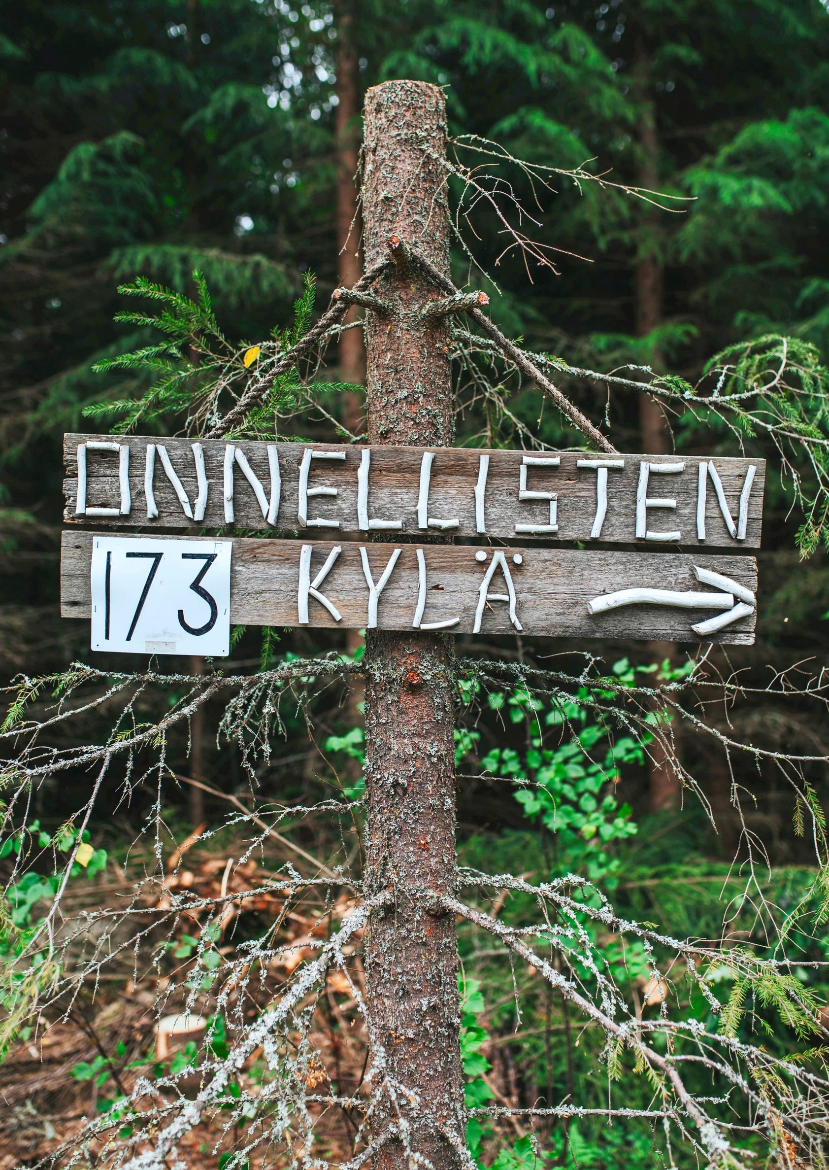 Onnellisten kylä -kyltti