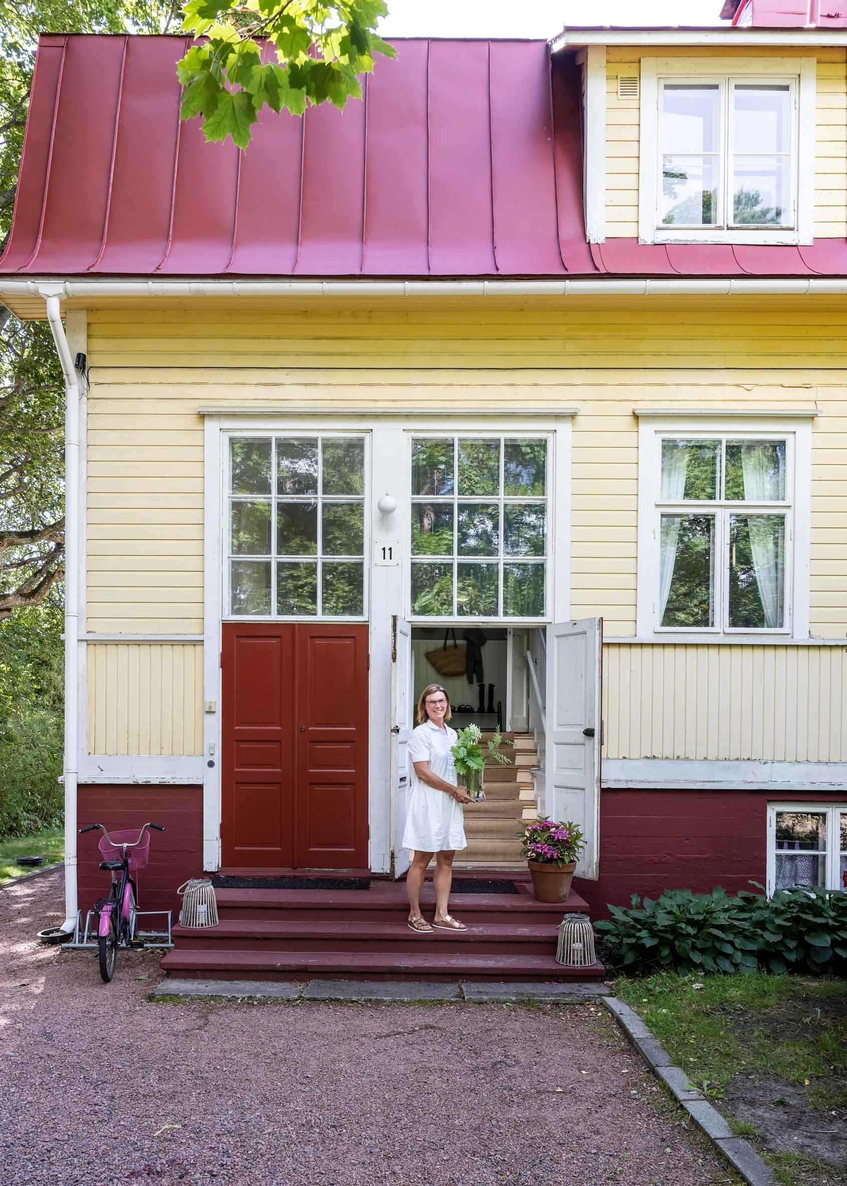 Riikka Mäenpää keltaisen huvilan rappusilla